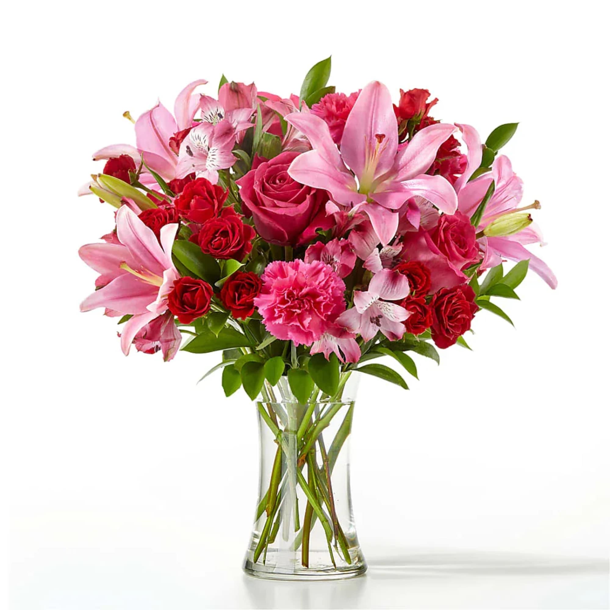 Pink lilies and red roses arranged in a clear glass vase