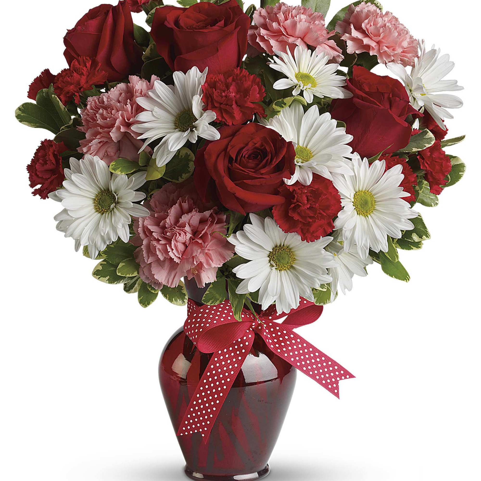 Red roses, pink carnations, and white daisies in a red vase with a polka-dot ribbon.