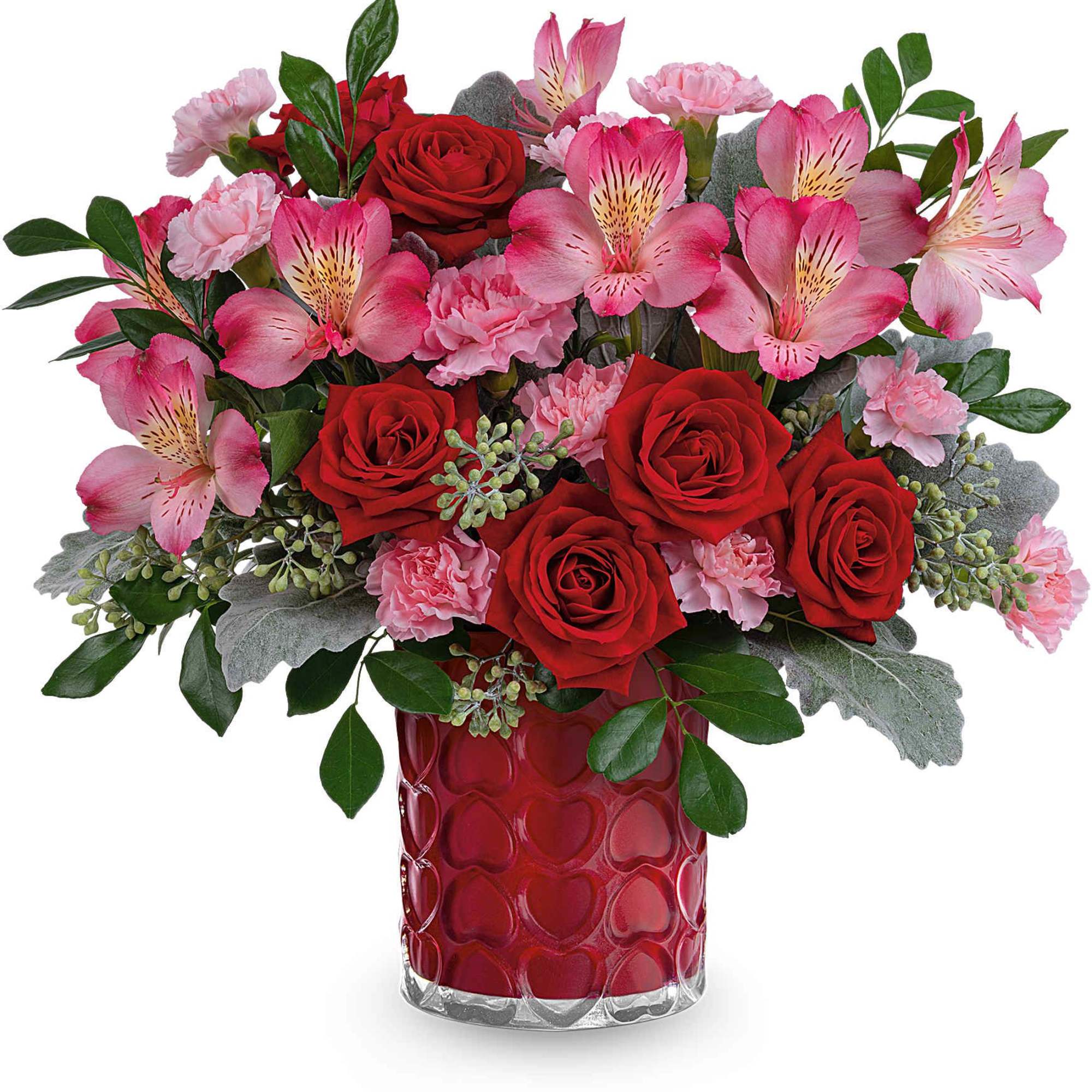 Red roses and pink flowers in a red heart-pattern vase