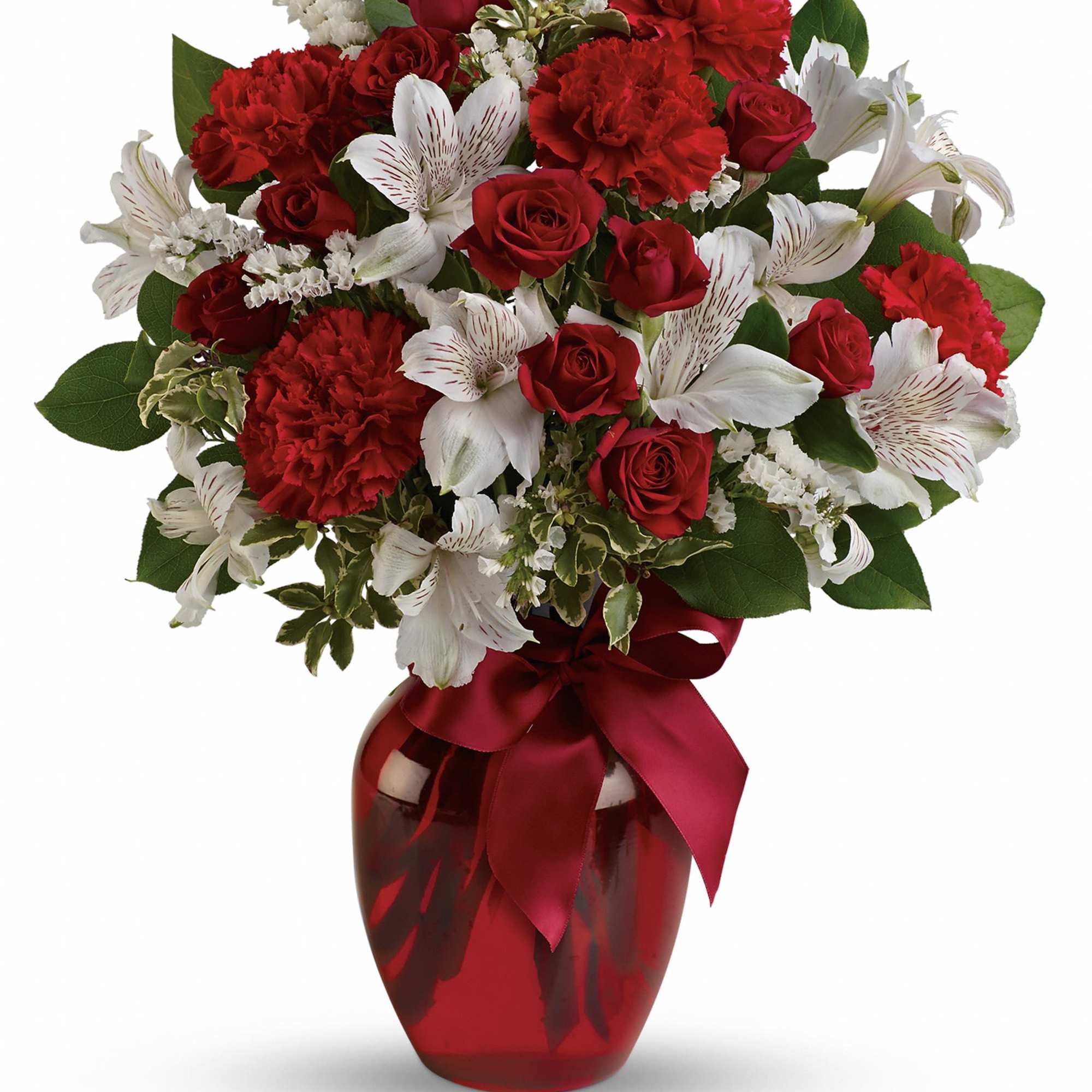 Red roses and white lilies in a red glass vase with a ribbon