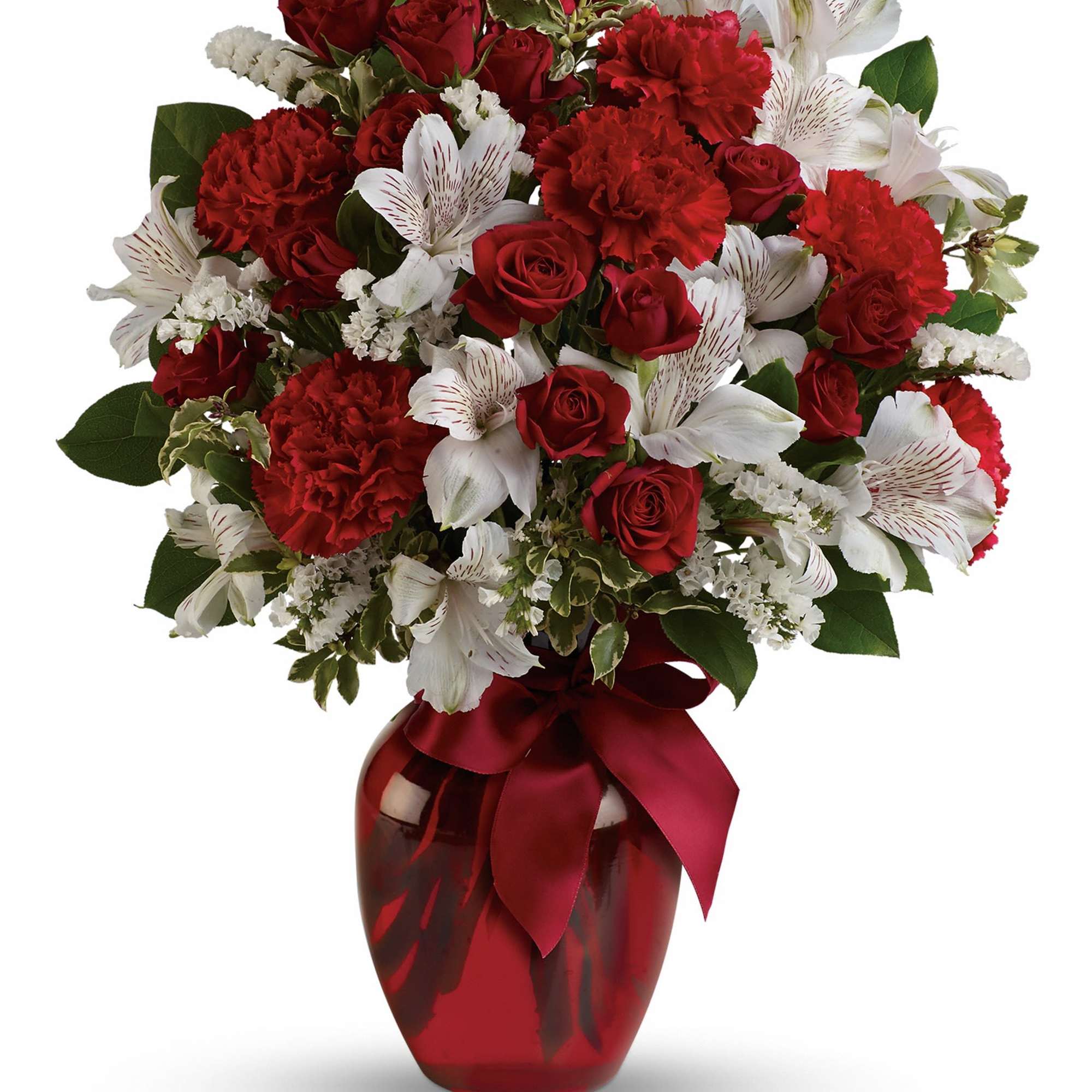 Red roses, carnations, and white lilies in a red vase with a ribbon