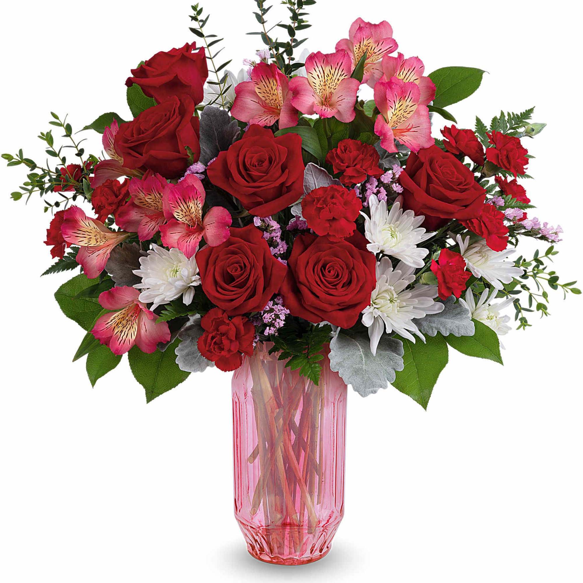 Red roses and pink alstroemeria in a pink glass vase