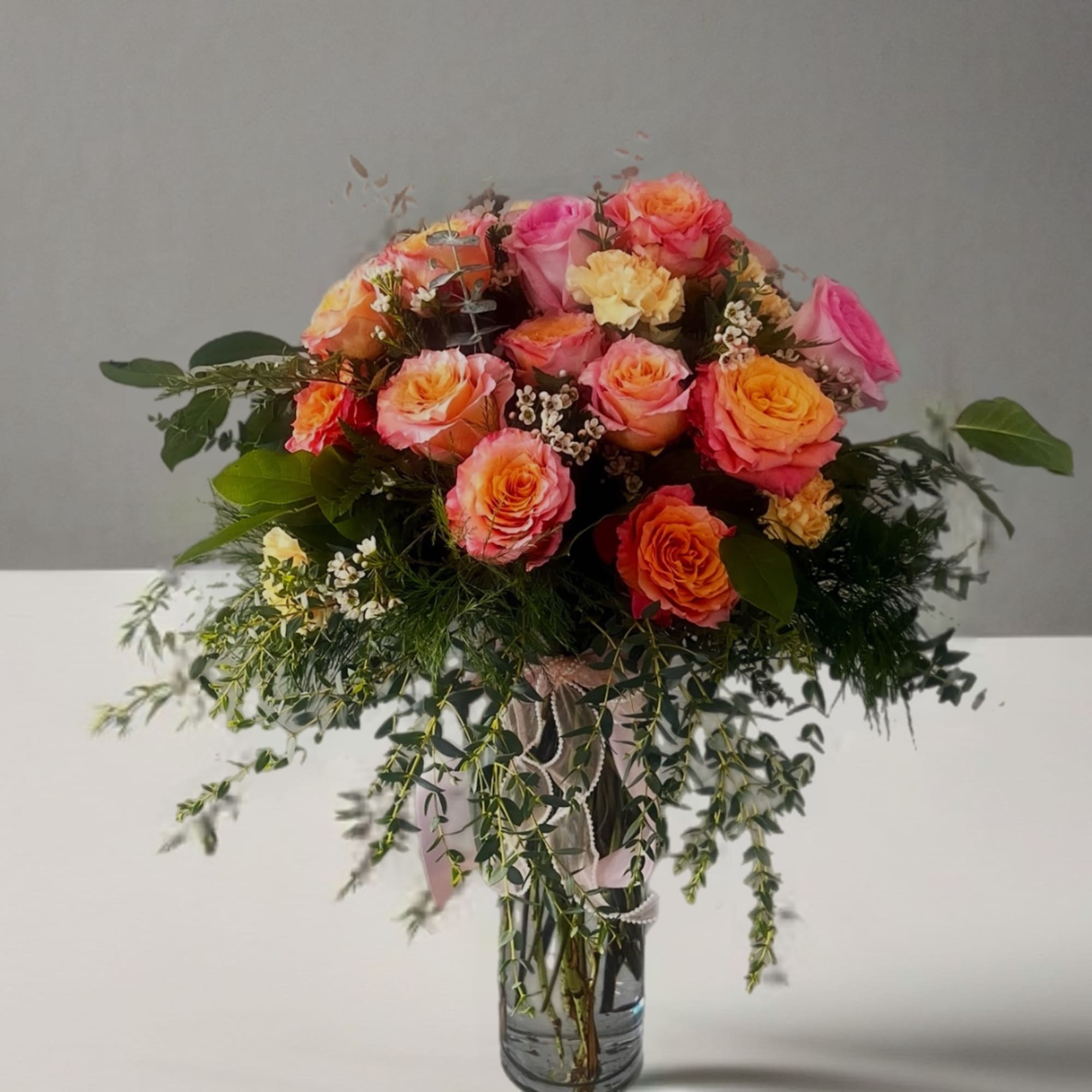 Bouquet of pink and orange roses in a glass vase