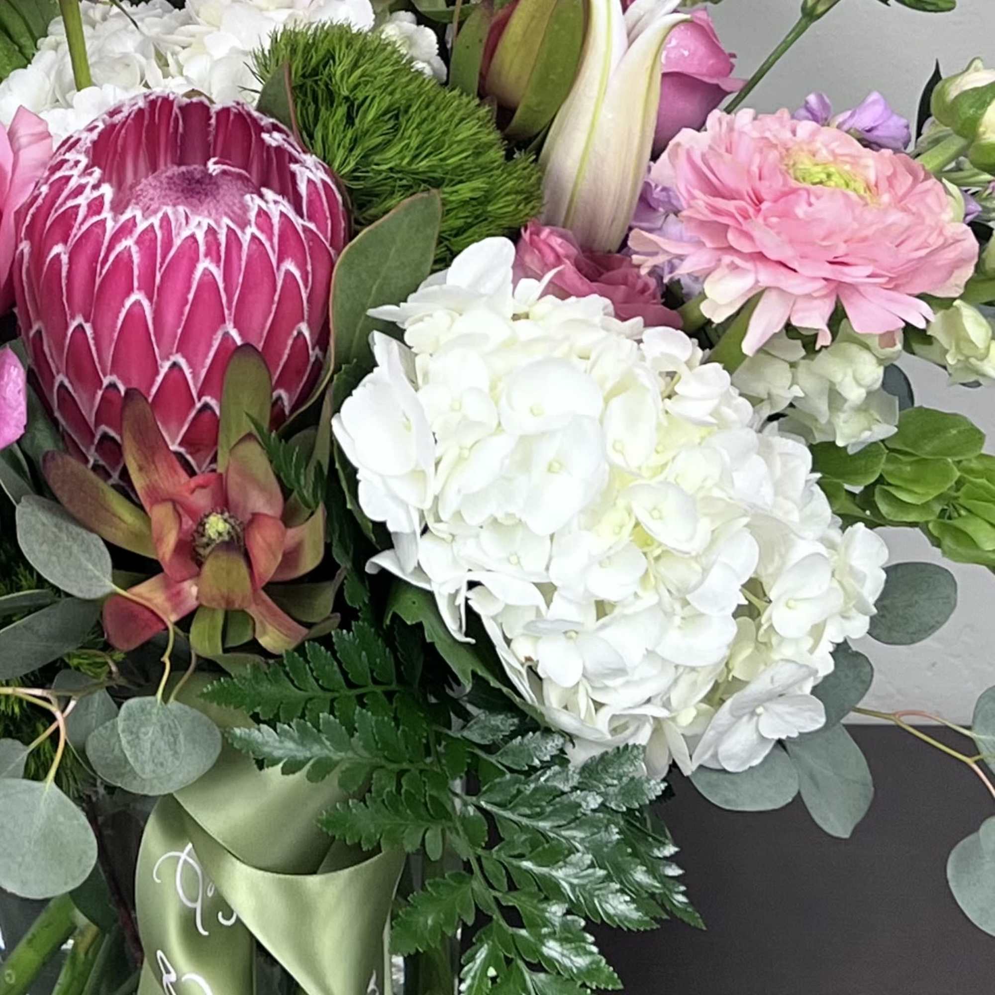 Bouquet with pink protea, white hydrangea, and pink blooms
