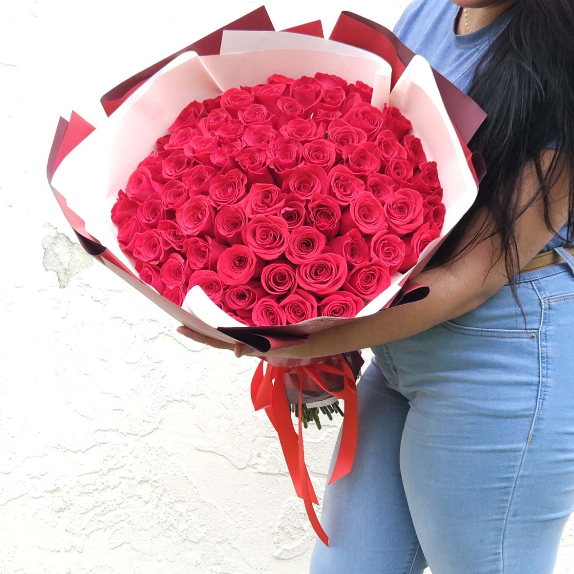 Large bouquet of hot pink roses wrapped in white and red paper