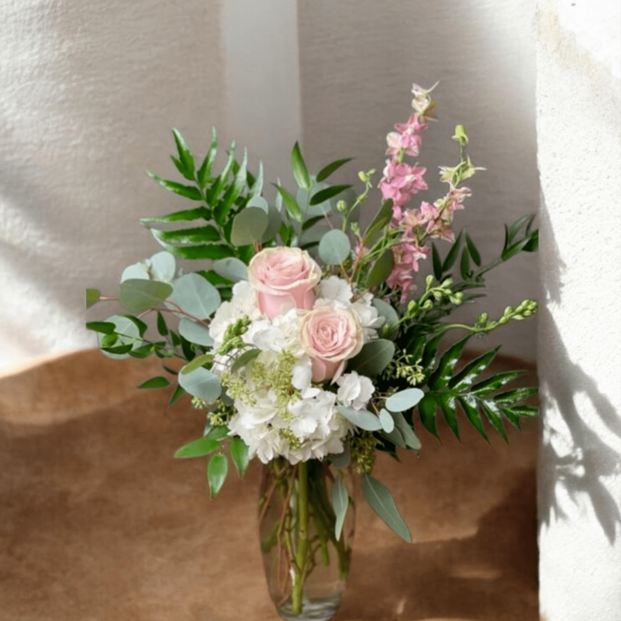 Soft pale pink roses nestled against clusters of white hydrangeas give this