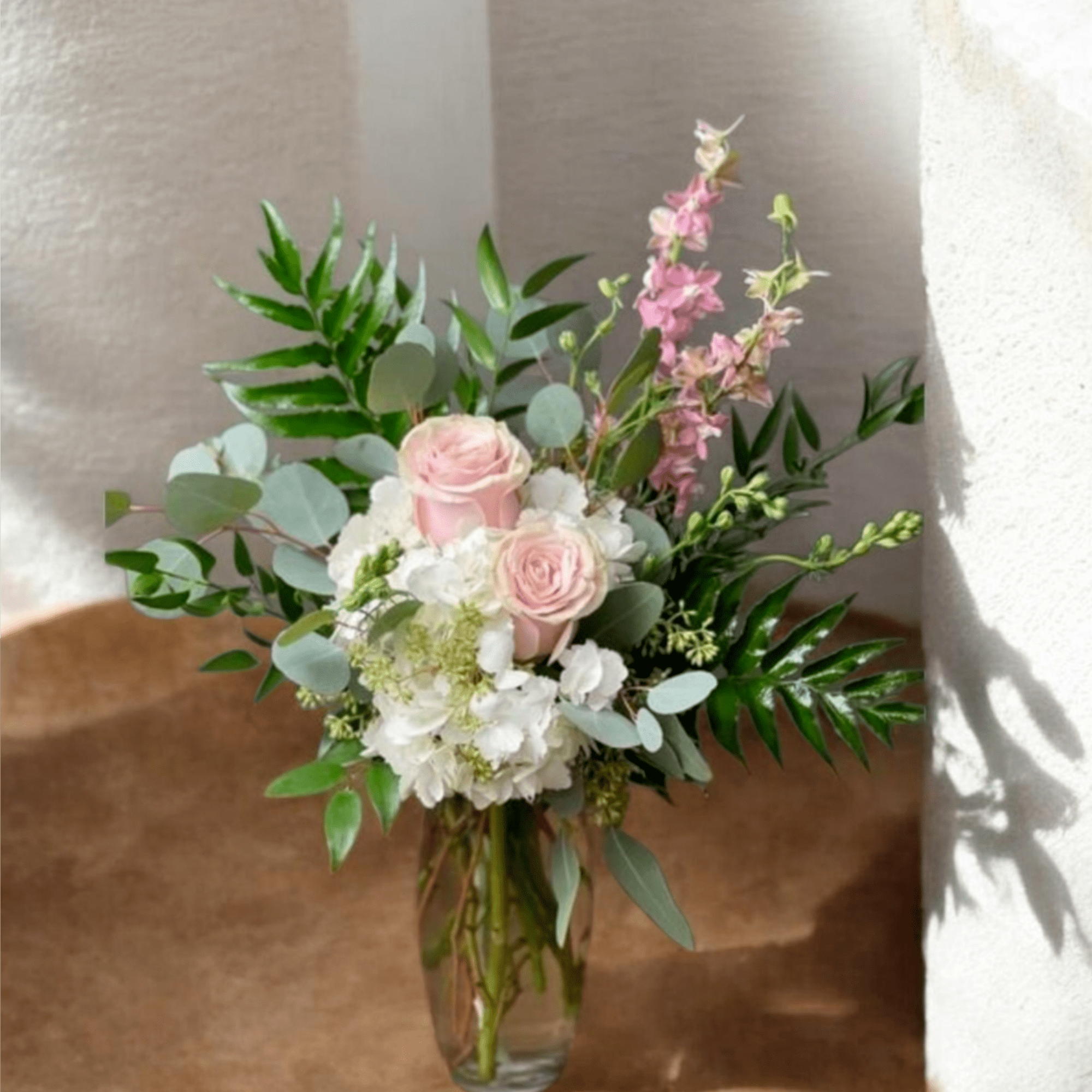 Soft pale pink roses nestled against clusters of white hydrangeas give this