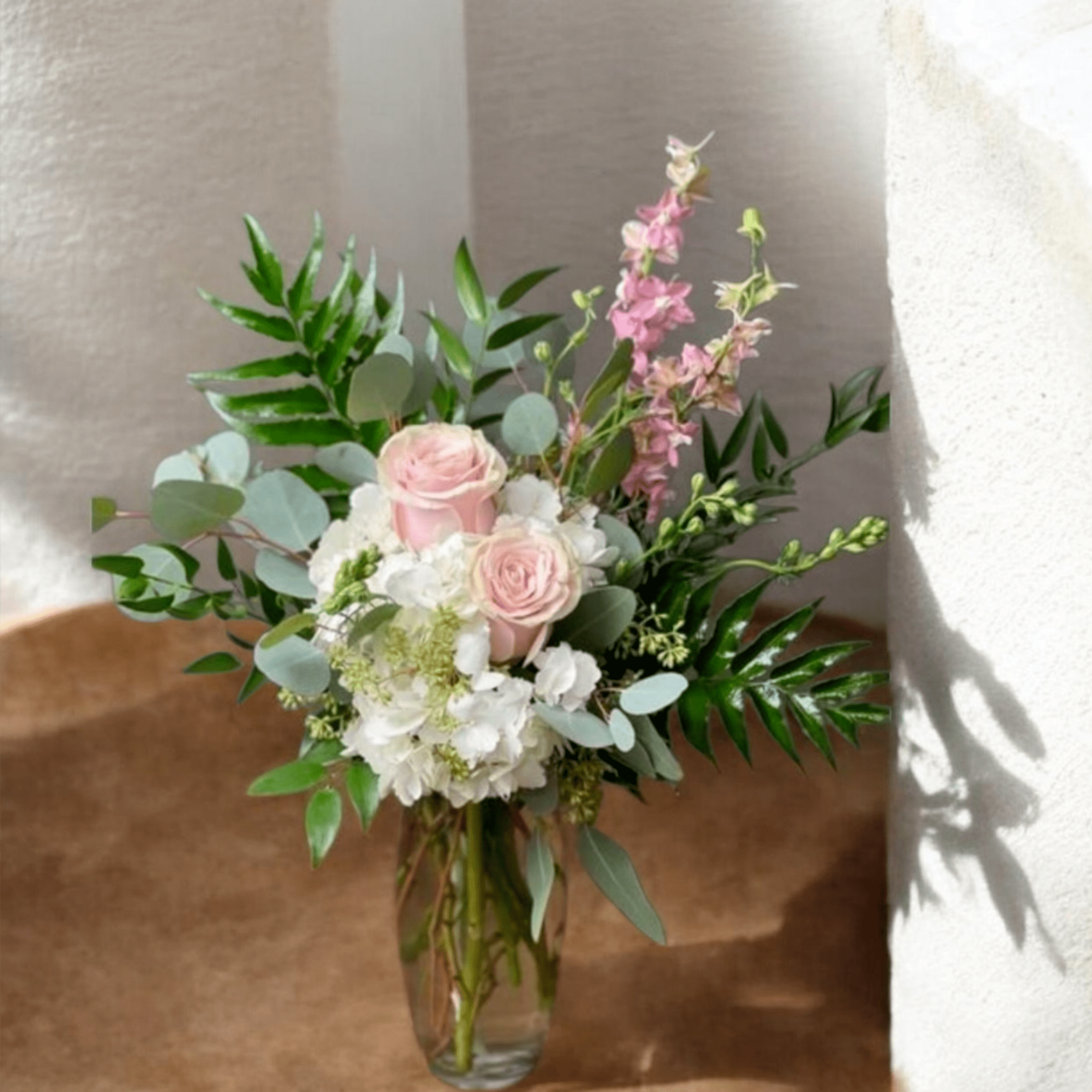 Soft pale pink roses nestled against clusters of white hydrangeas give this