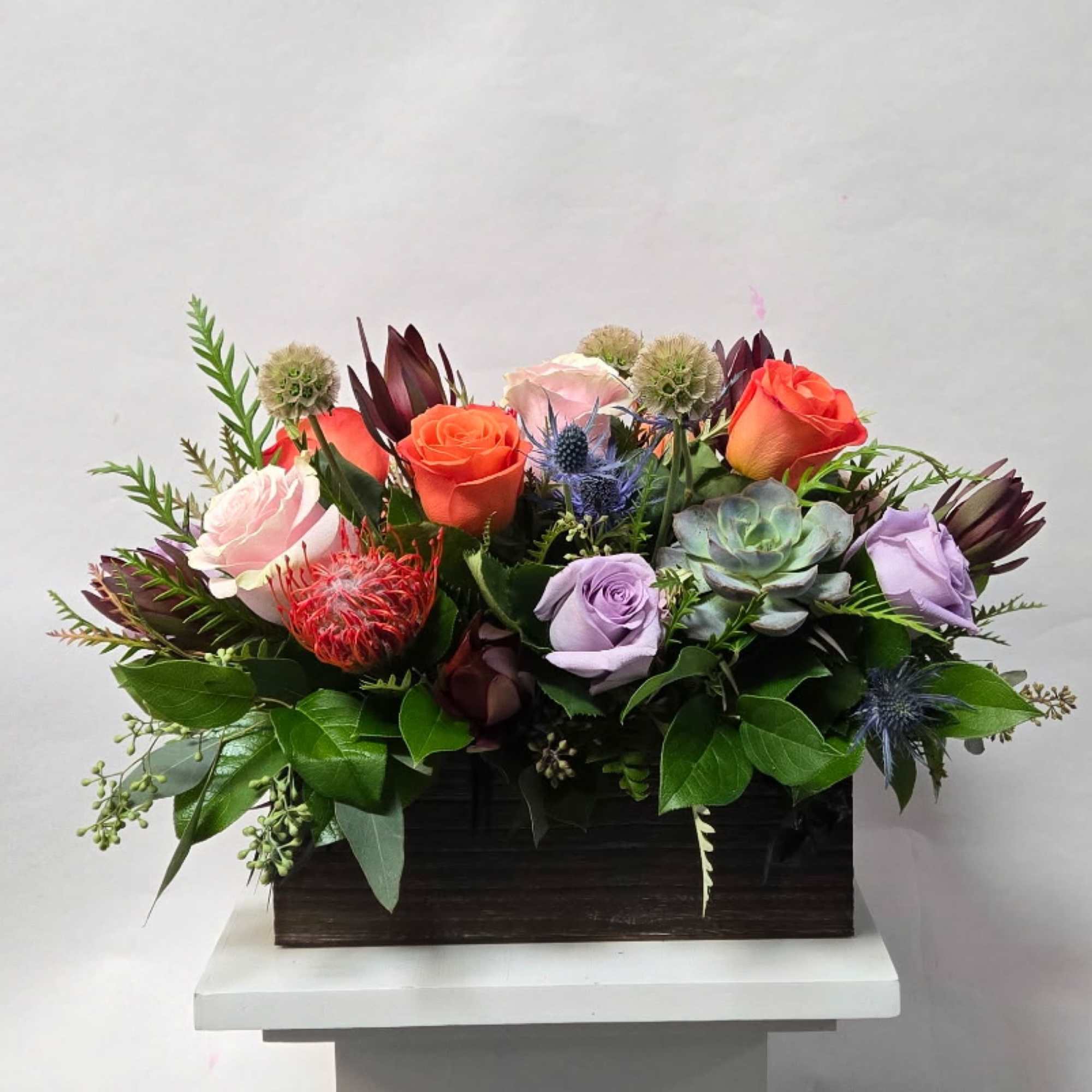 A Low and Airy Bright Spring Mixed Centerpiece in a Rectangular Wooden