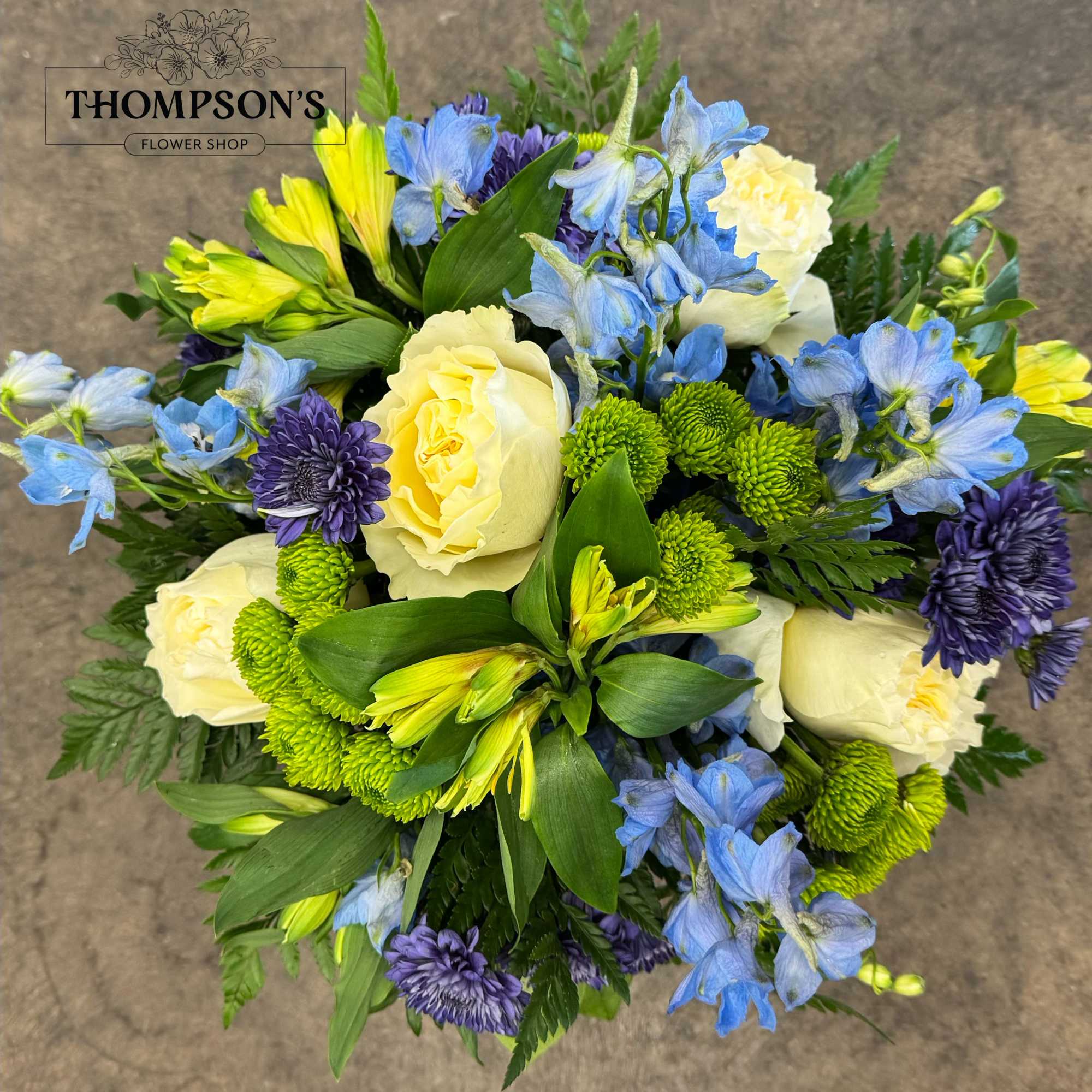 Bouquet of cream roses, blue flowers, and green mums