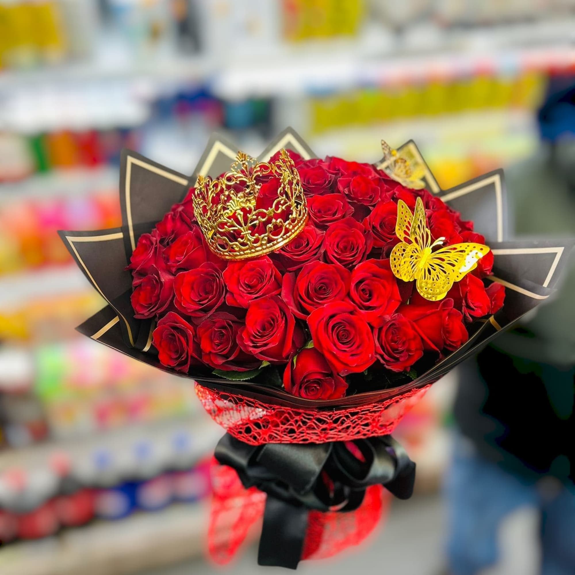 Bouquet of red roses with a gold crown and butterfly accents