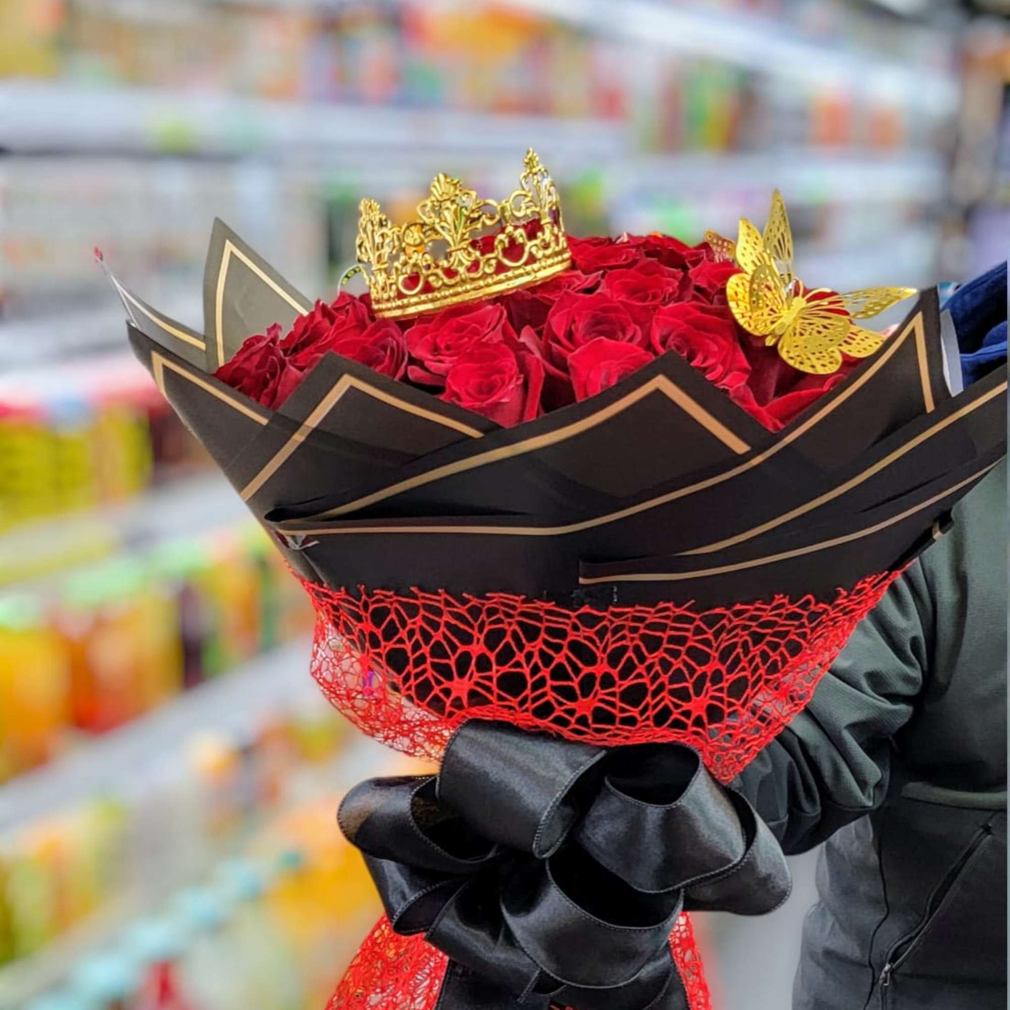 Bouquet of red roses with a gold crown and black ribbon wrap