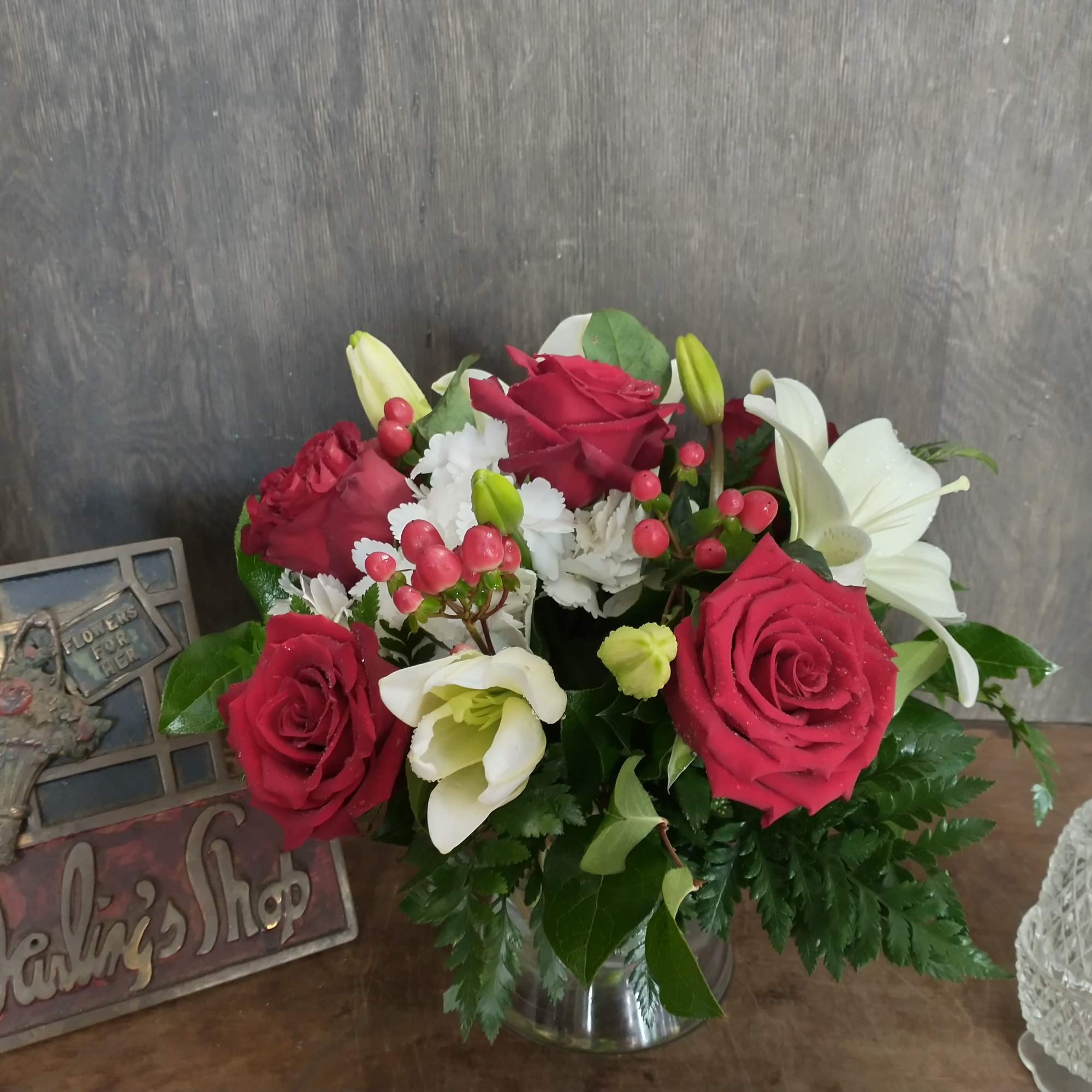 Red roses and white lilies arranged in a glass vase