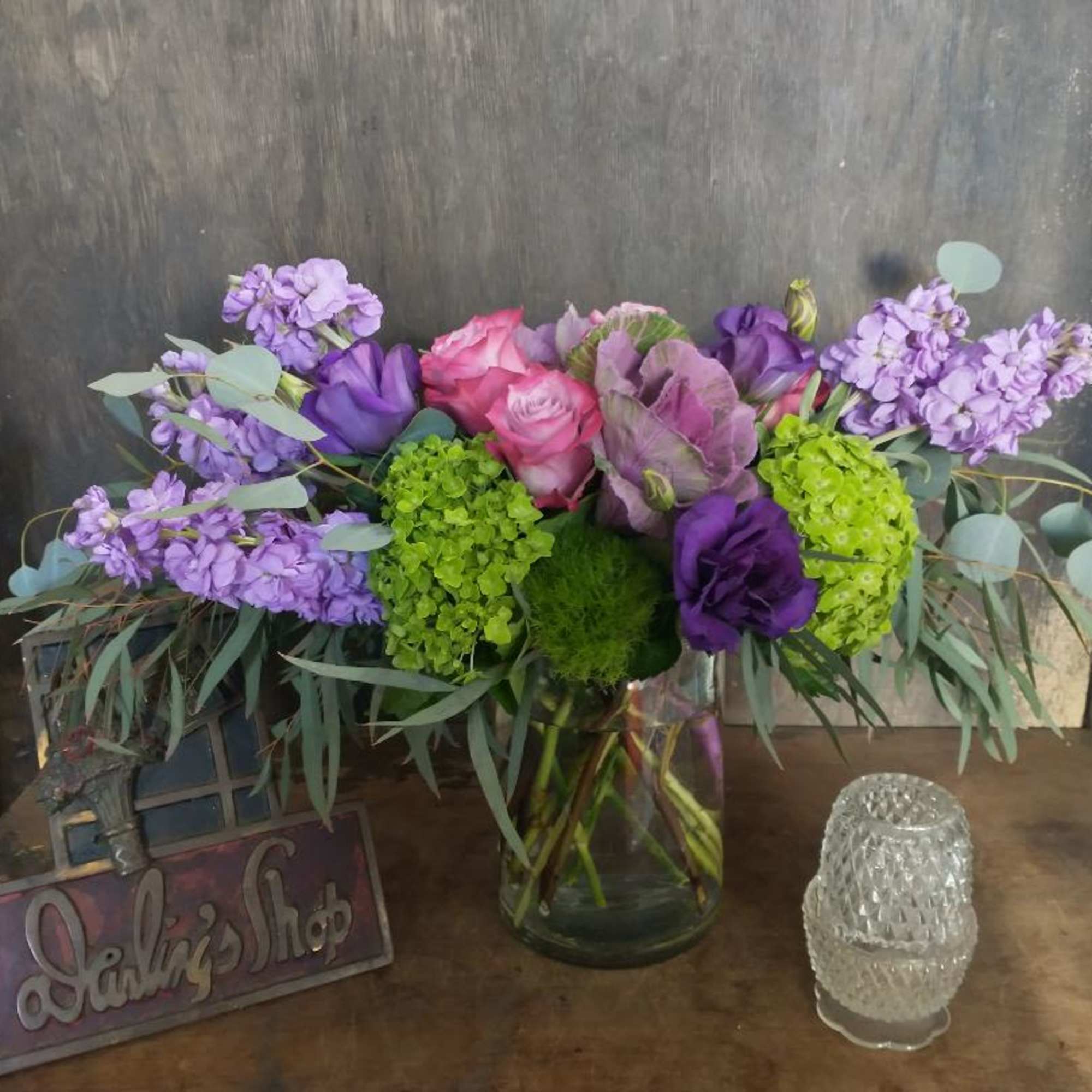 Bouquet of purple, pink, and green flowers in a glass vase