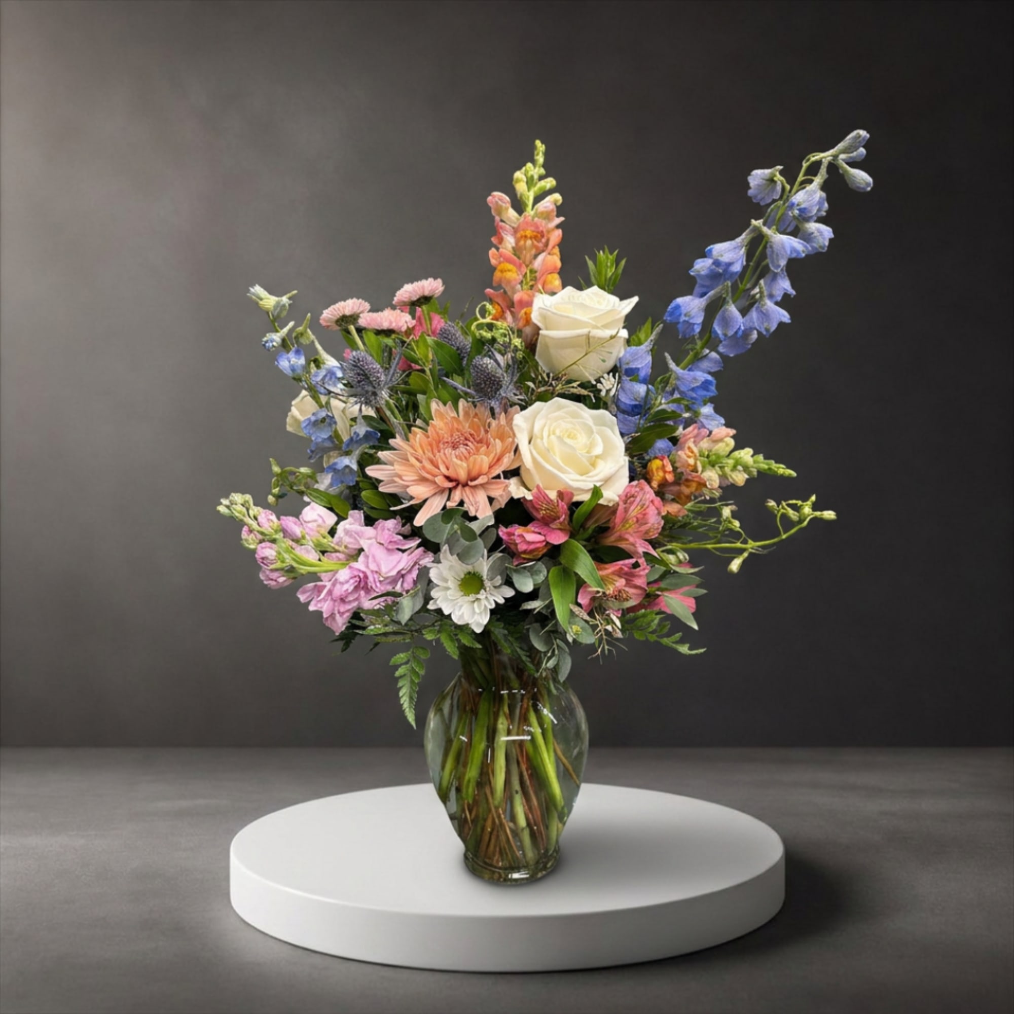 Mixed bouquet of pastel flowers in a clear glass vase