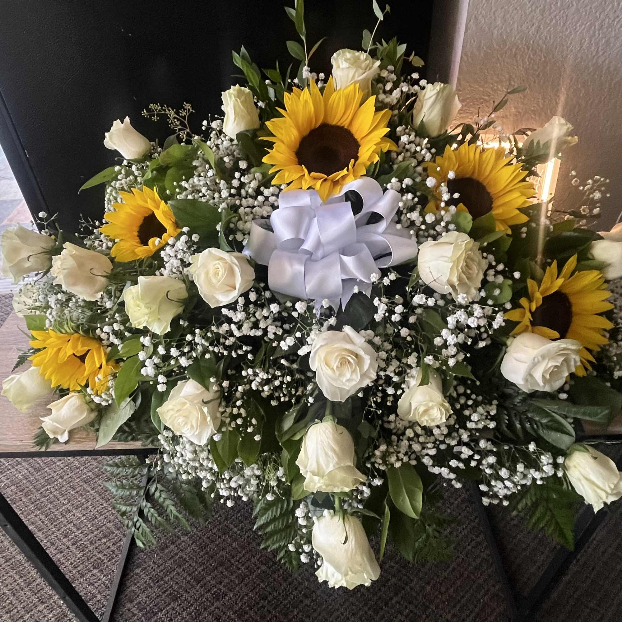 Sunflower and white rose arrangement with a white ribbon bow