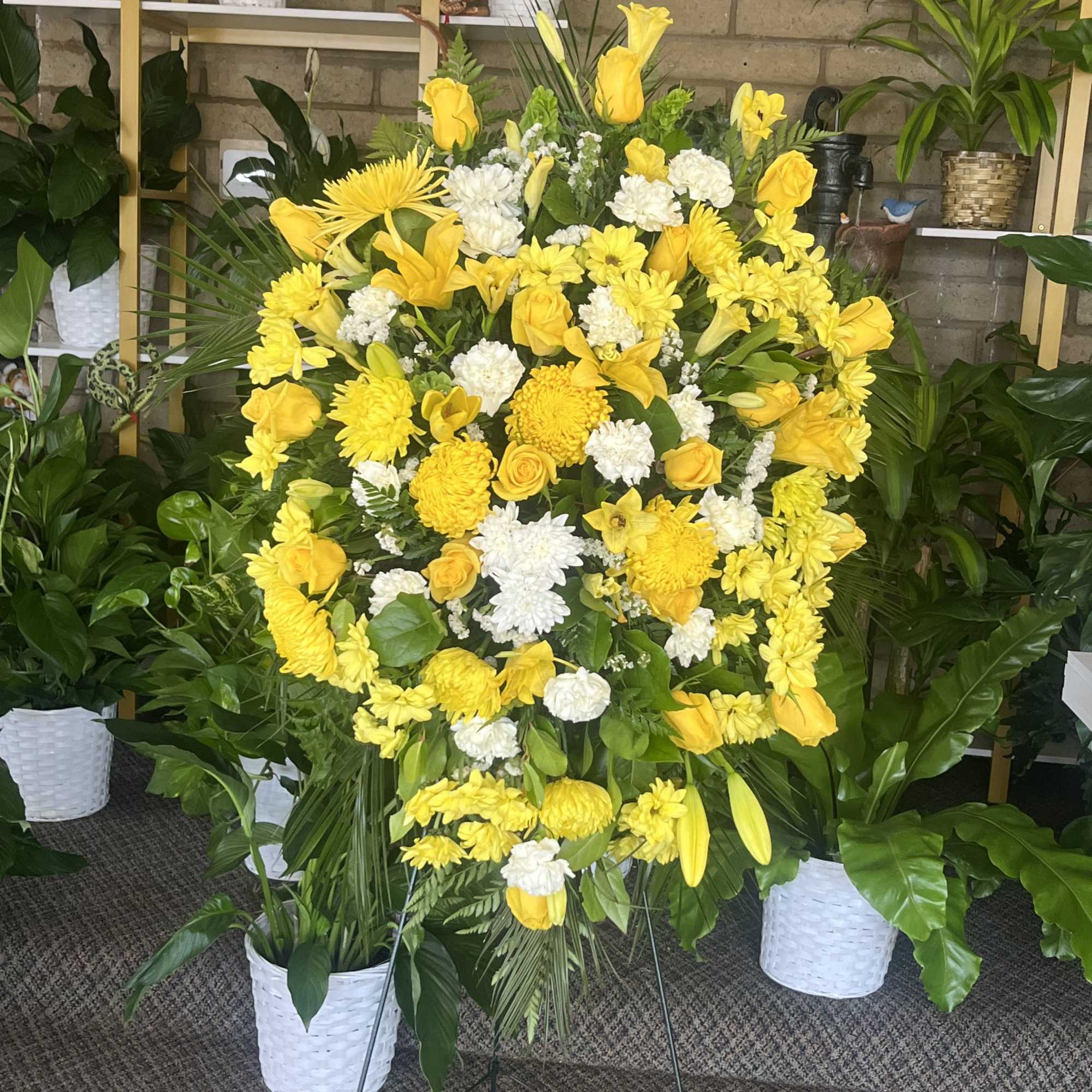 Large yellow and white floral standing spray on an easel