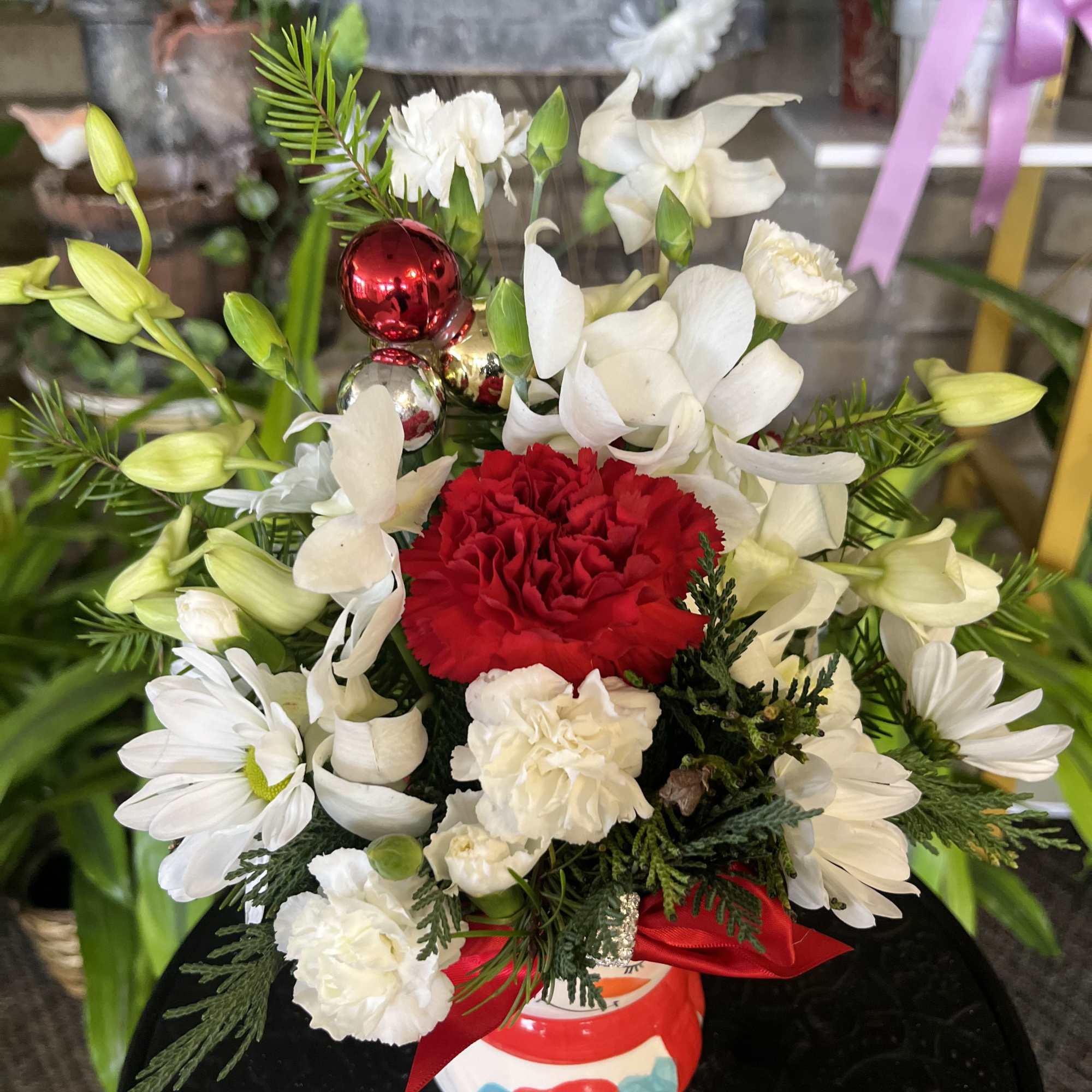 White and red floral arrangement in a decorated ceramic vase