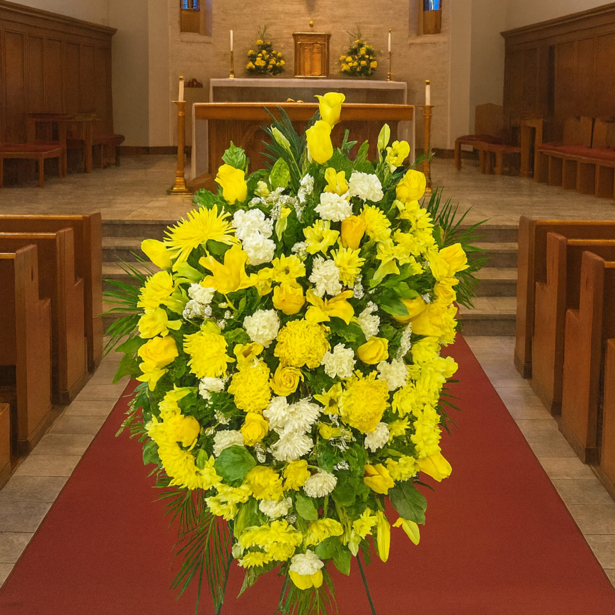 Large yellow and white funeral spray on a stand in a church aisle