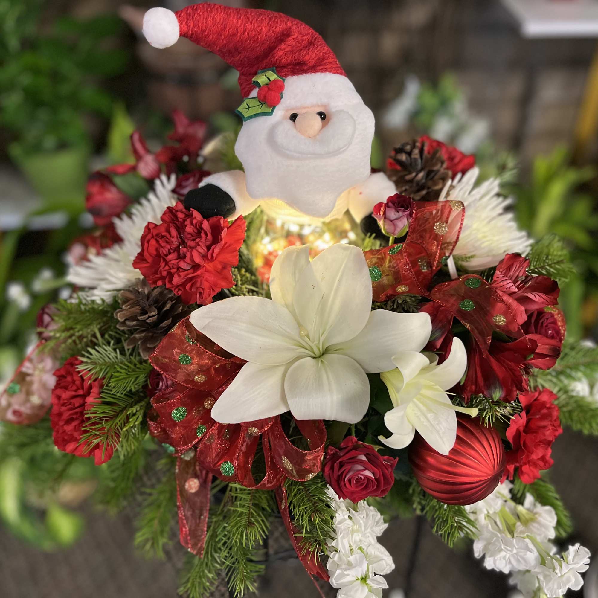 Christmas bouquet with a Santa topper, white lilies, and red flowers