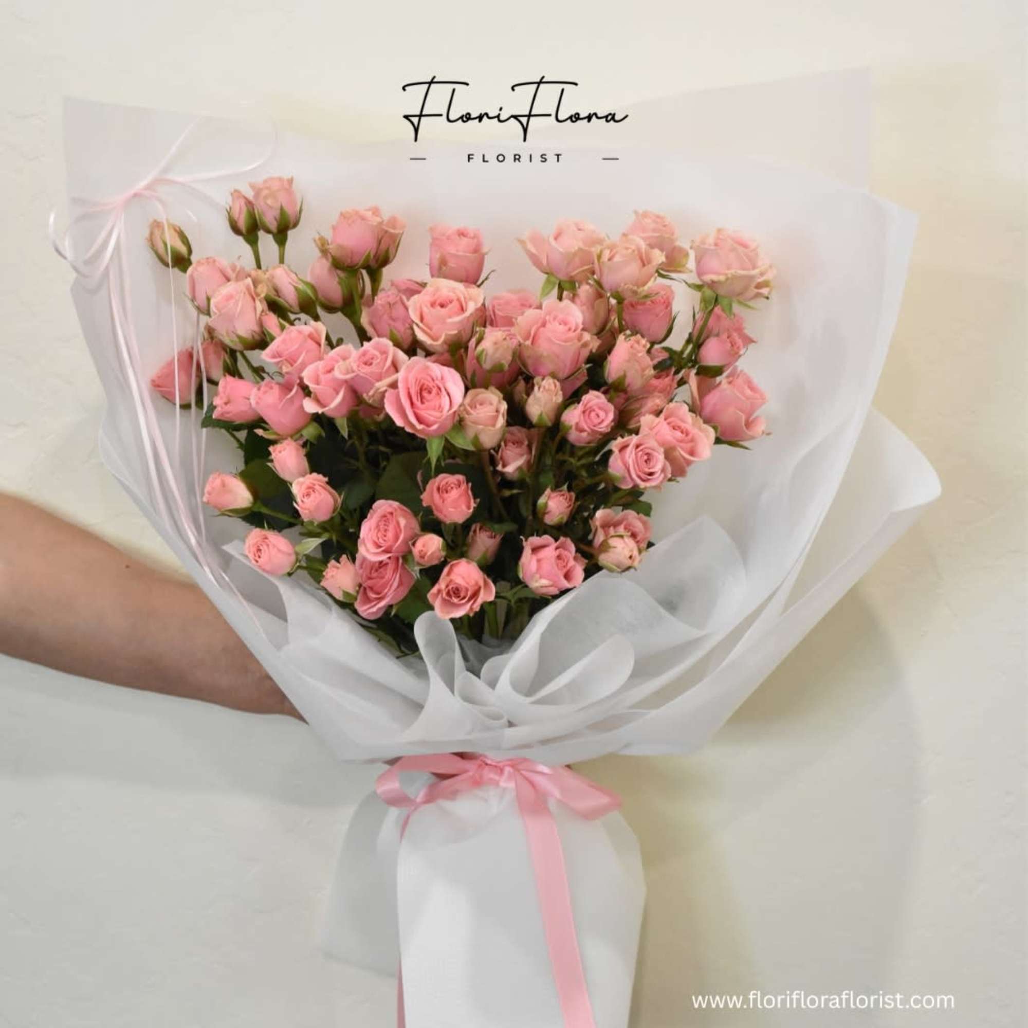 A dreamy bouquet of delicate pink mini roses, lovingly wrapped in fancy