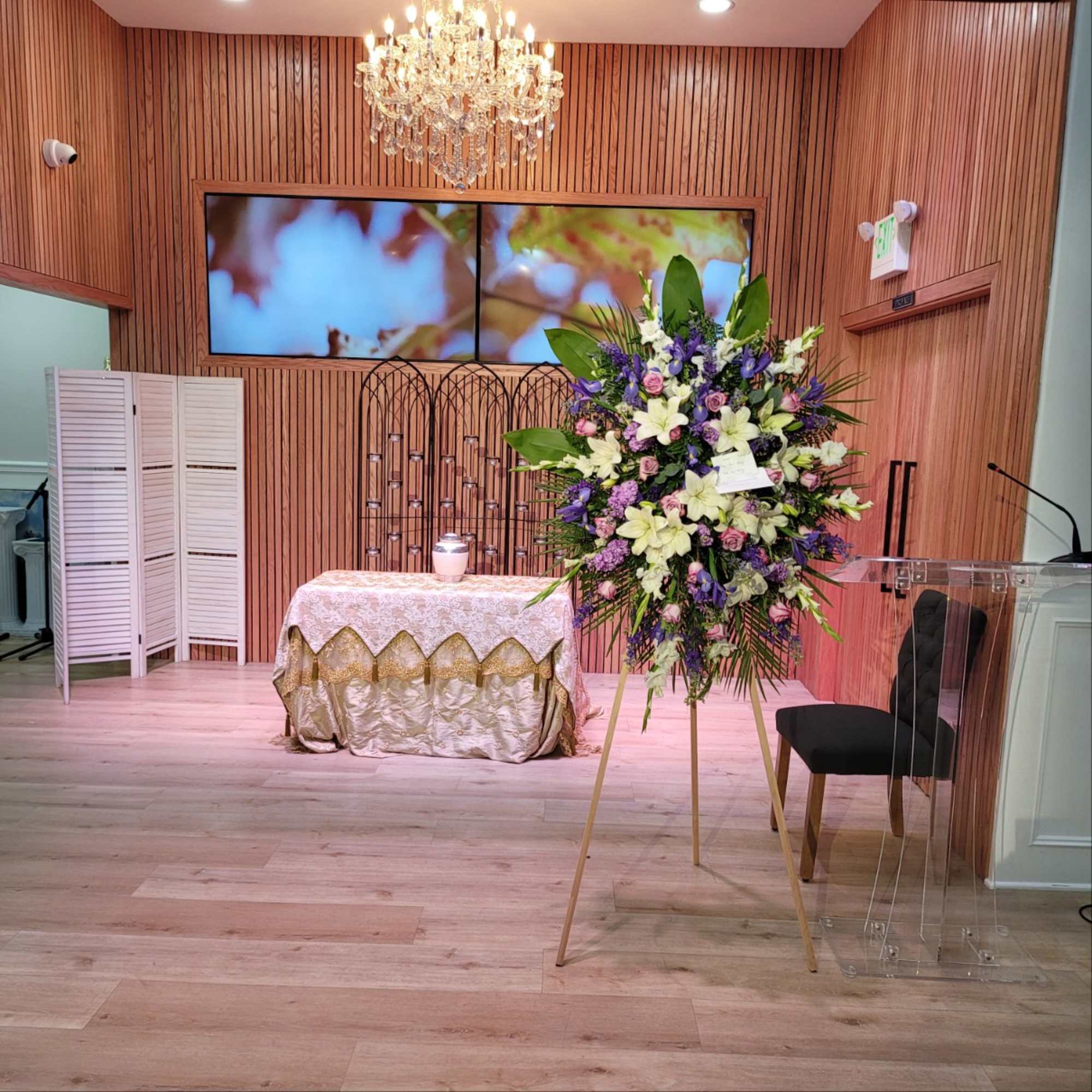 Large standing floral spray with white lilies and purple flowers