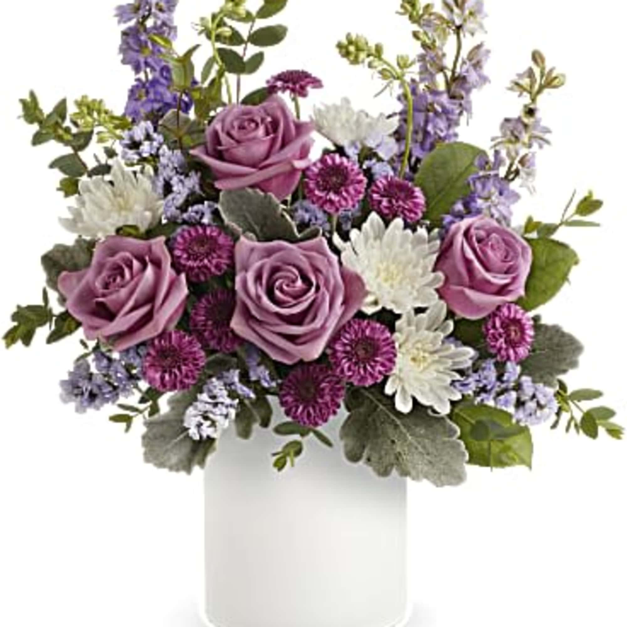 Lavender roses and purple-white mixed flowers in a white vase