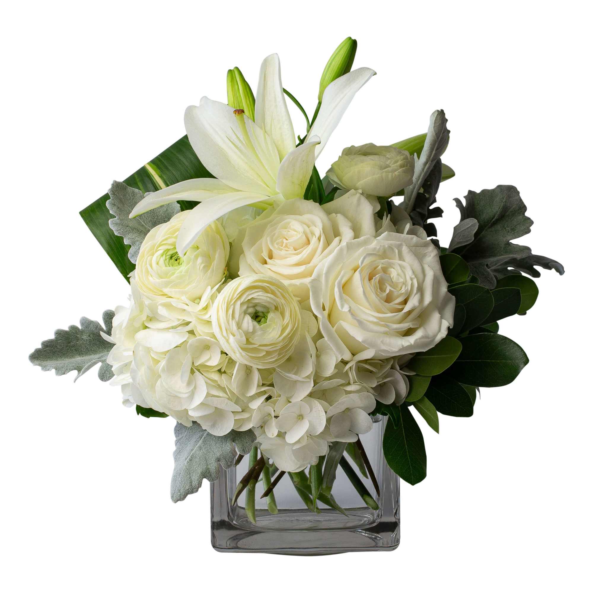 White roses and lilies arranged in a square glass vase