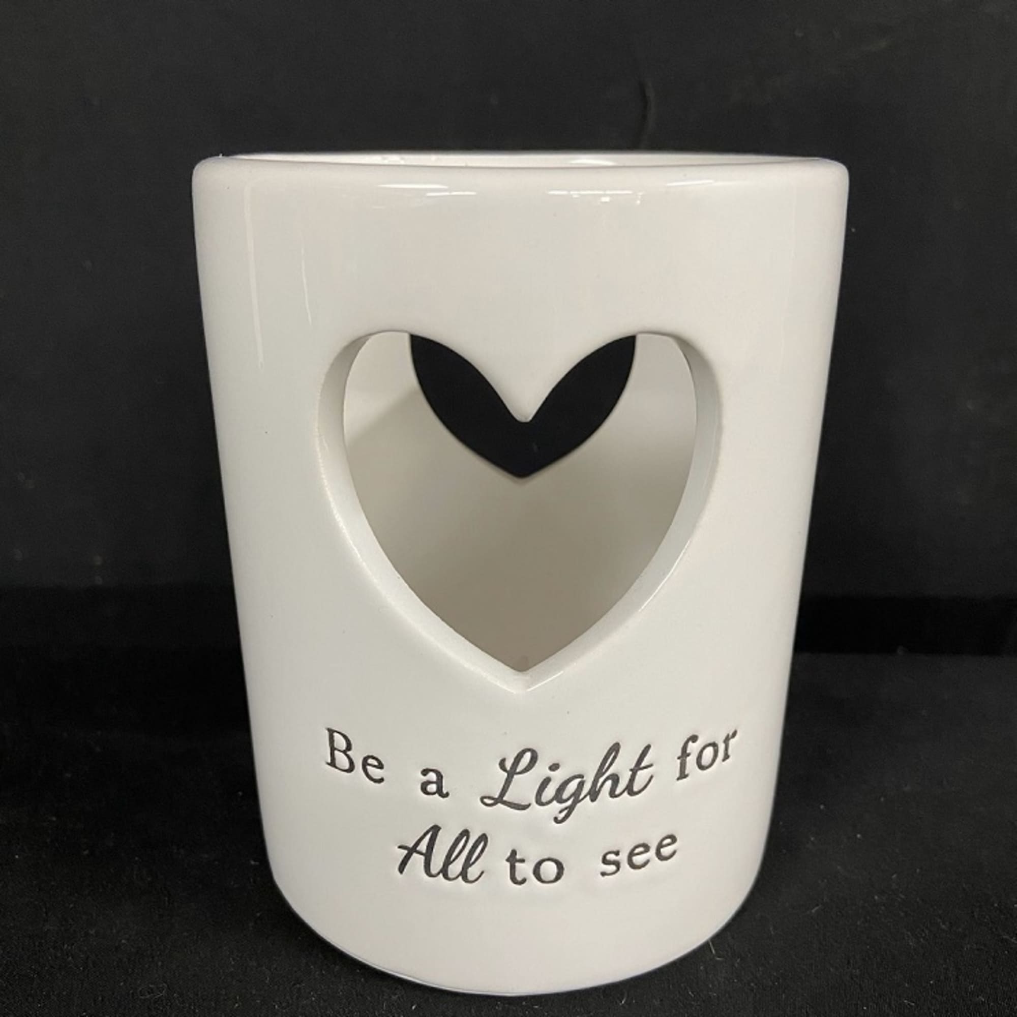 White ceramic candle holder with a heart cutout and printed text