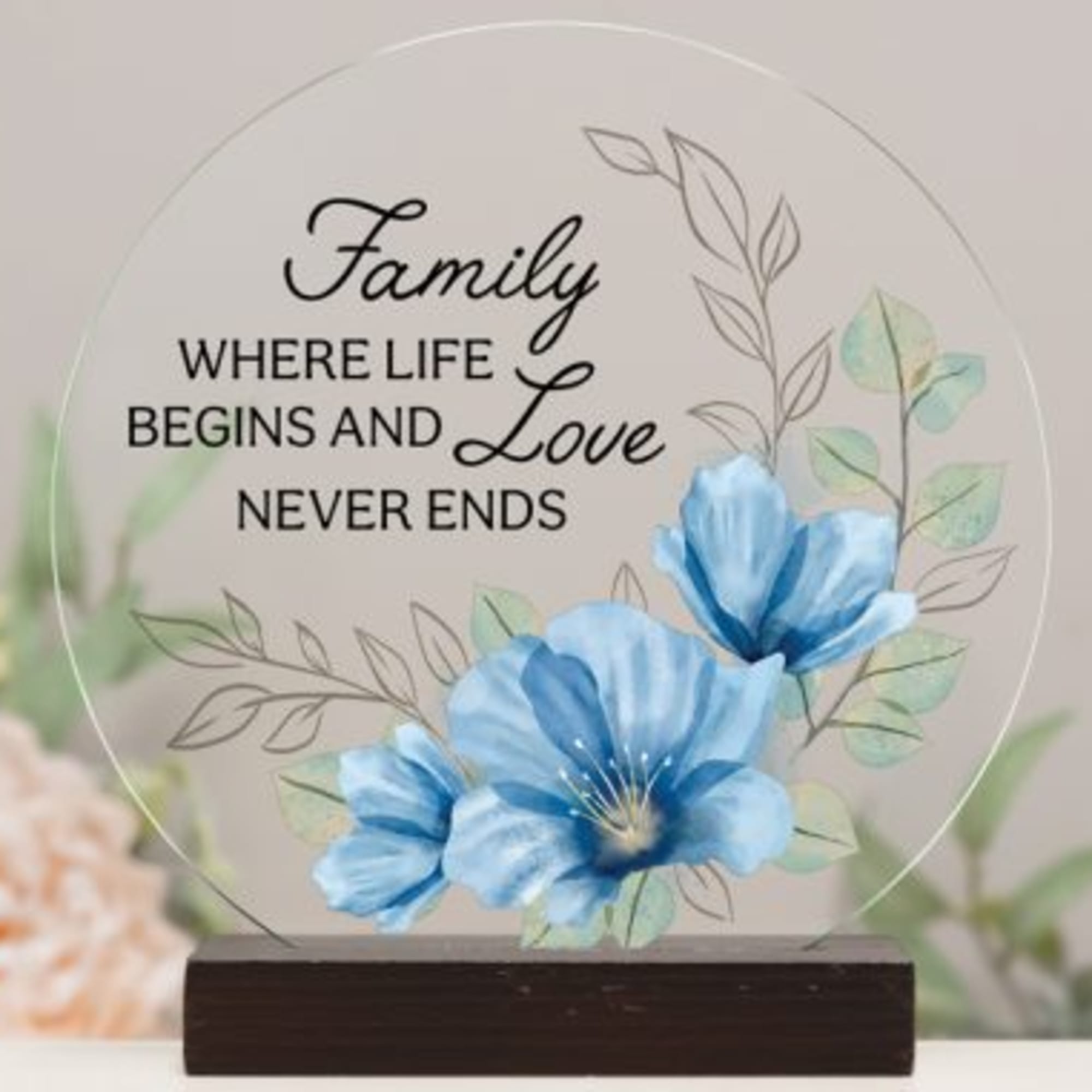 Decorative plaque with blue flowers and the words "Family where life begins and love never ends"
