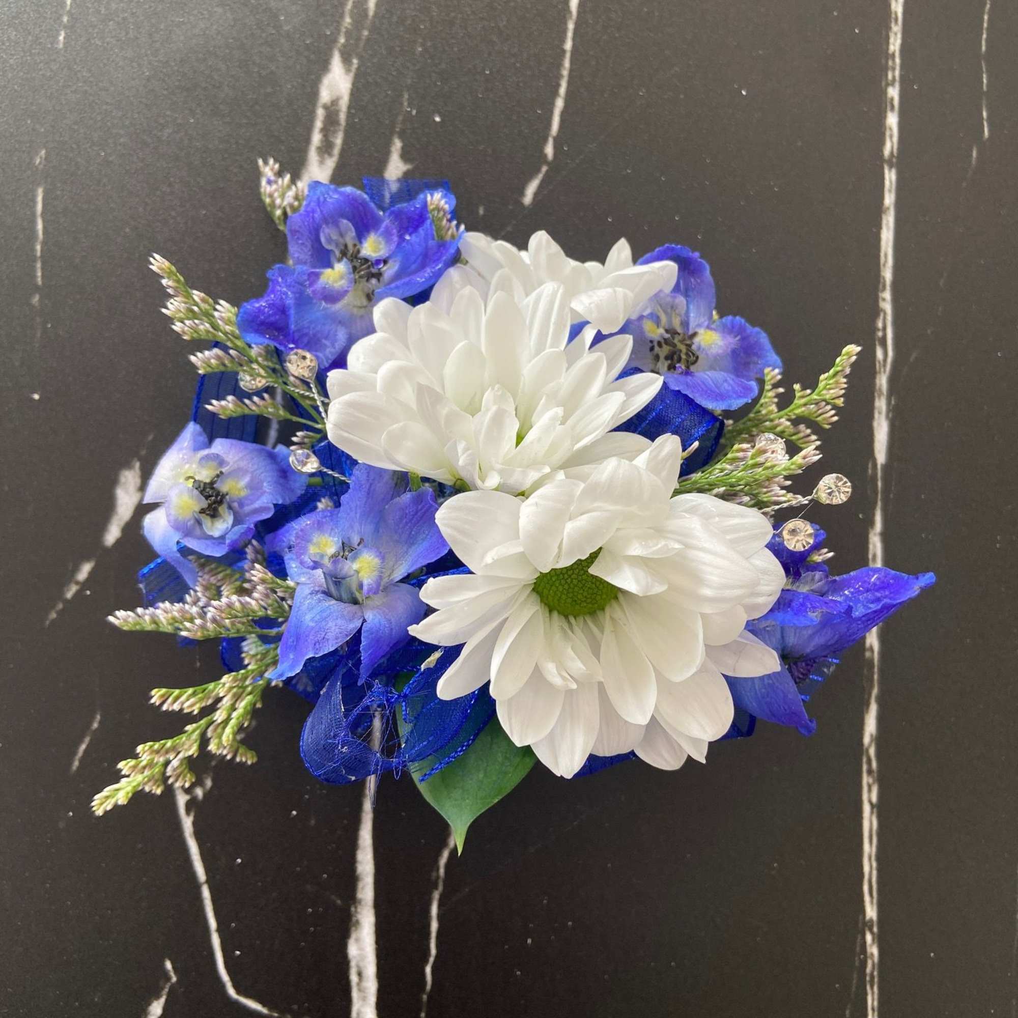 Blue and white floral corsage with daisy-like blooms