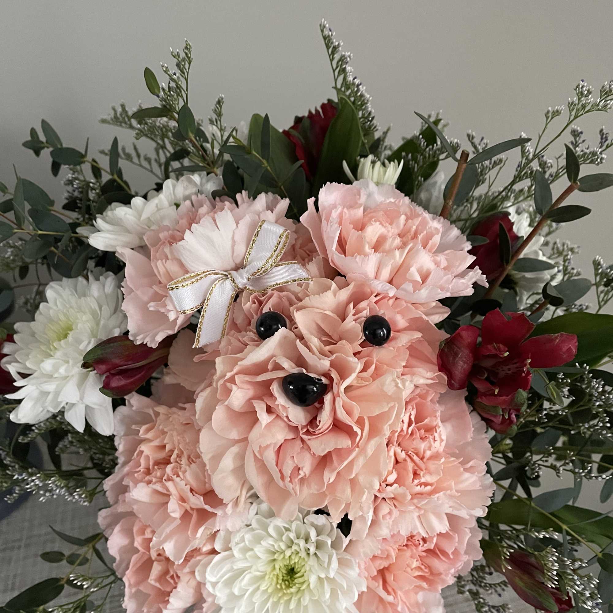 Pink carnations with white chrysanthemums and dark red flowers in a bouquet