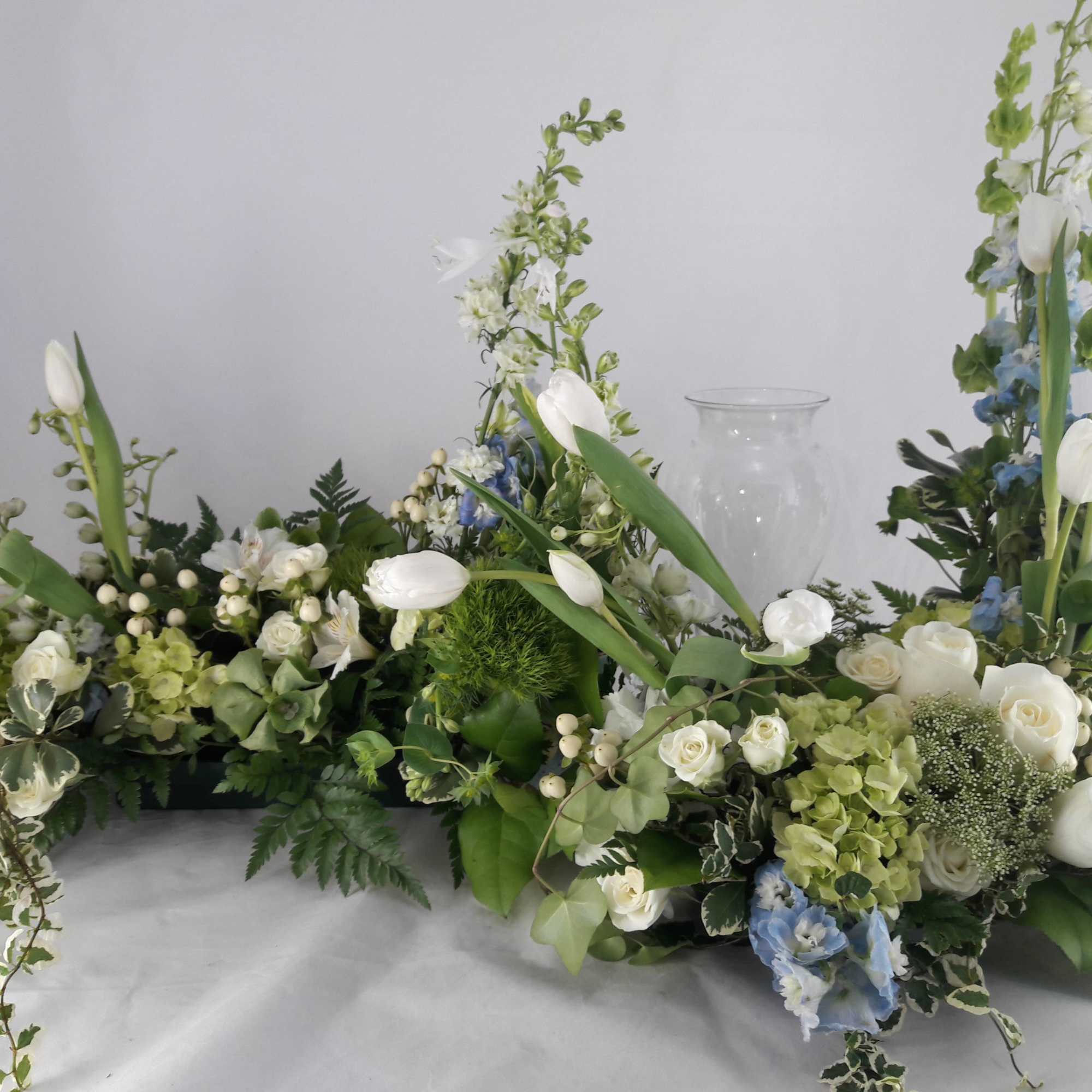 White and blue floral arrangements with tall tulips and roses