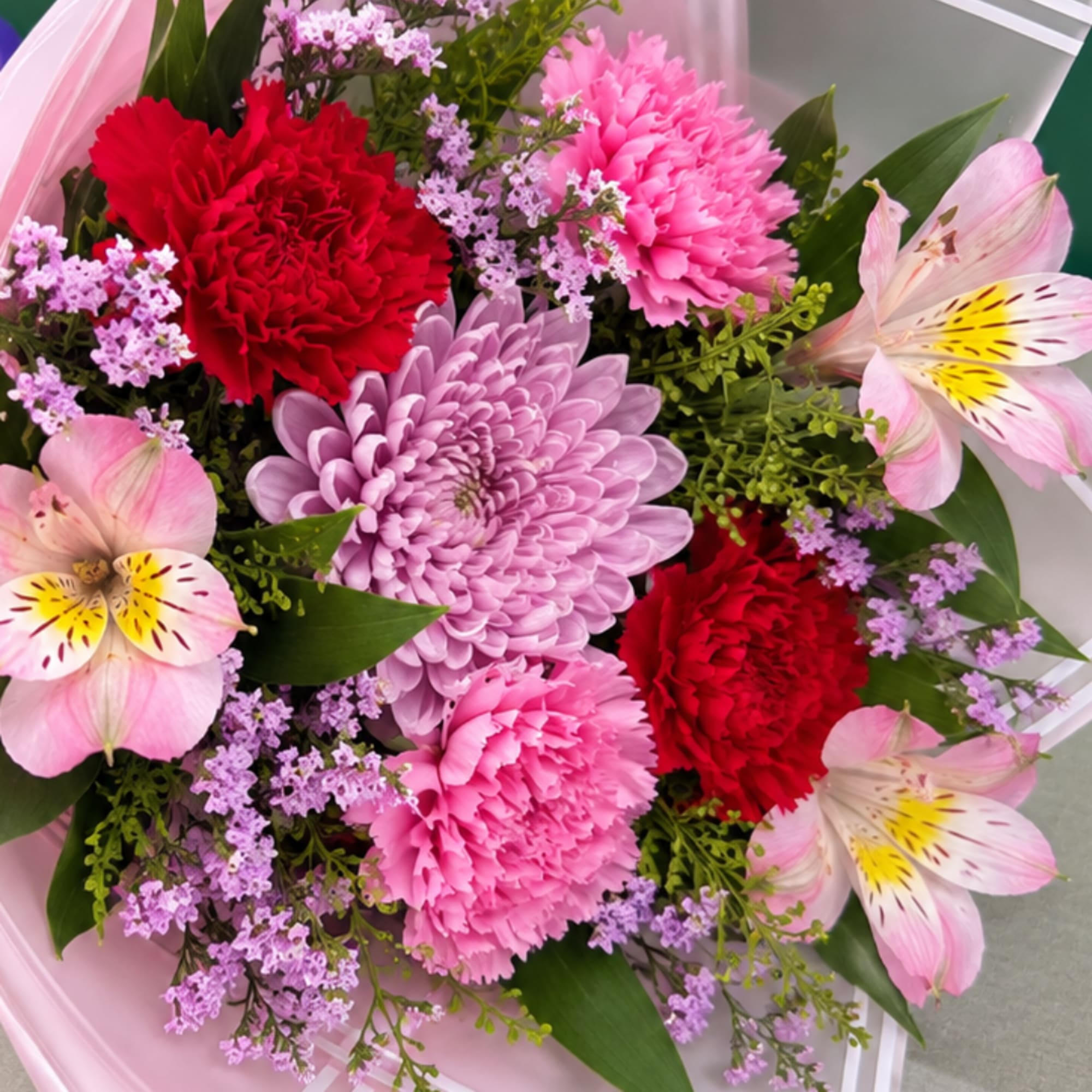 Bouquet of pink and red flowers with lavender accents and pale pink lilies