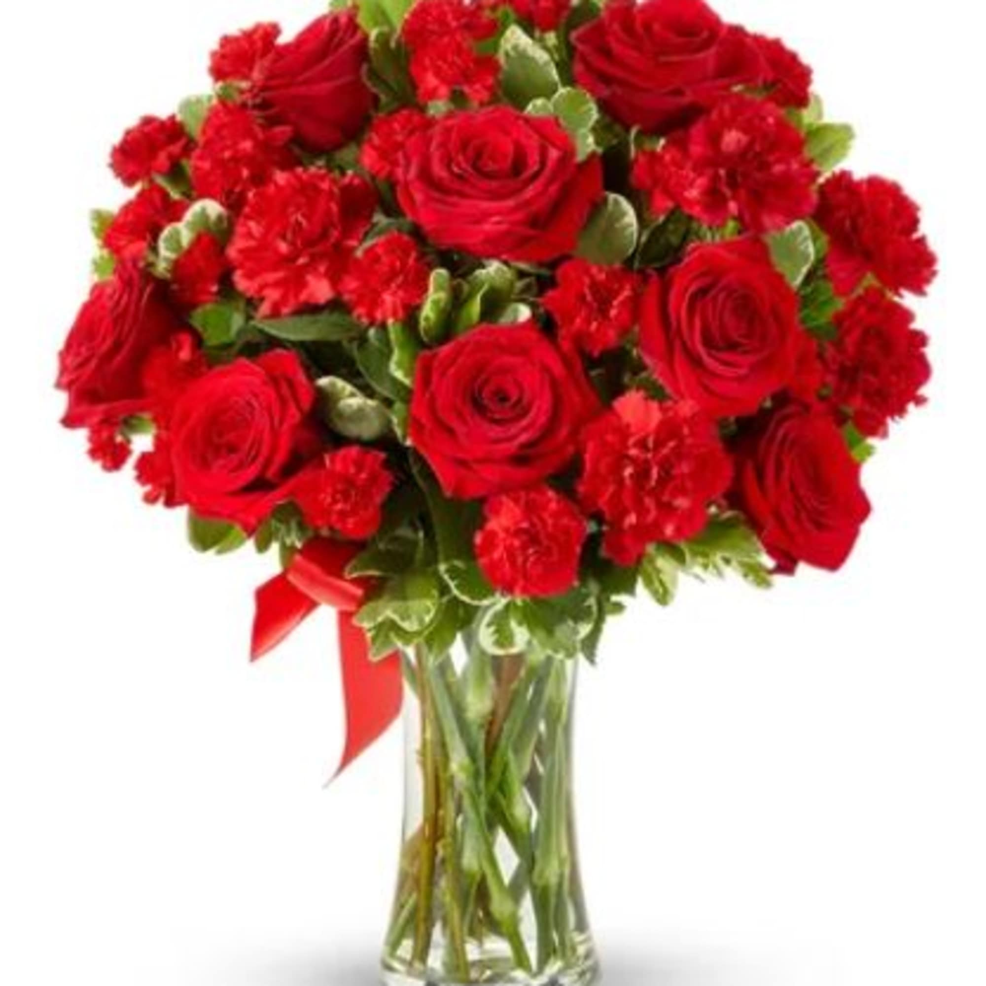 Red roses and carnations in a clear glass vase with a red ribbon