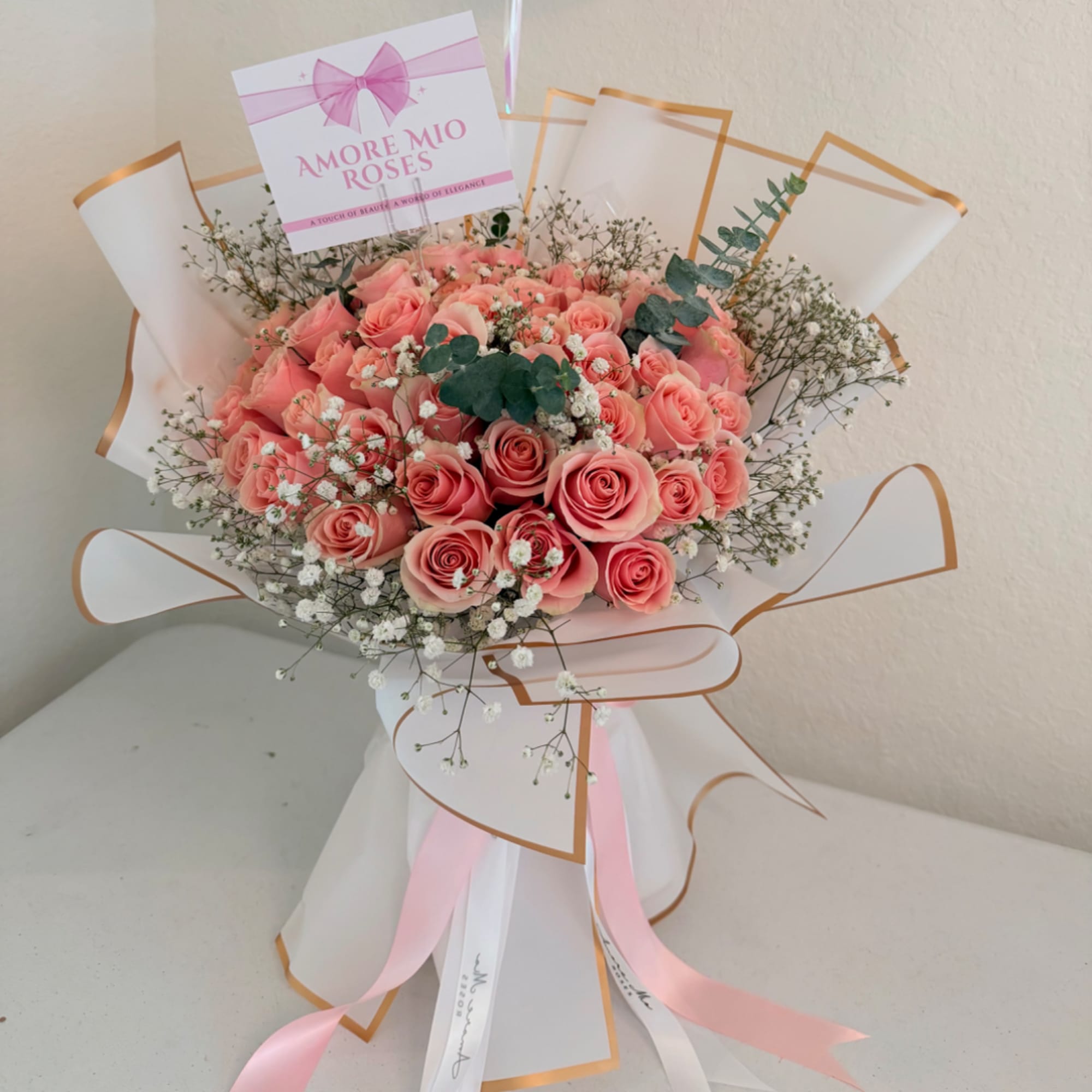 Bouquet of pink roses with baby's breath and ribbon wrapping