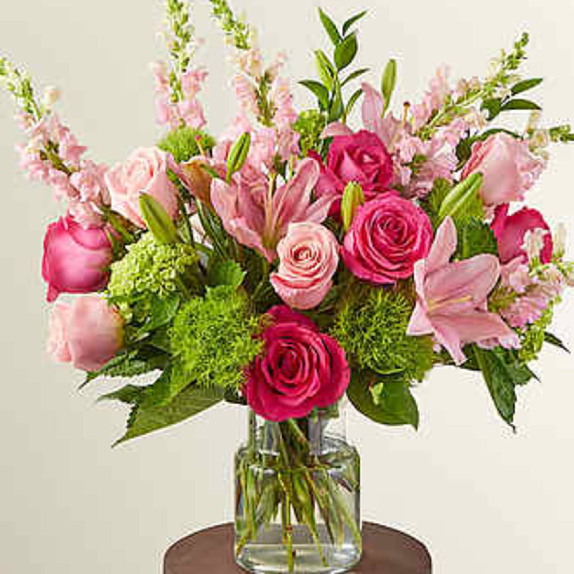 Pink and magenta flower arrangement in a clear glass vase