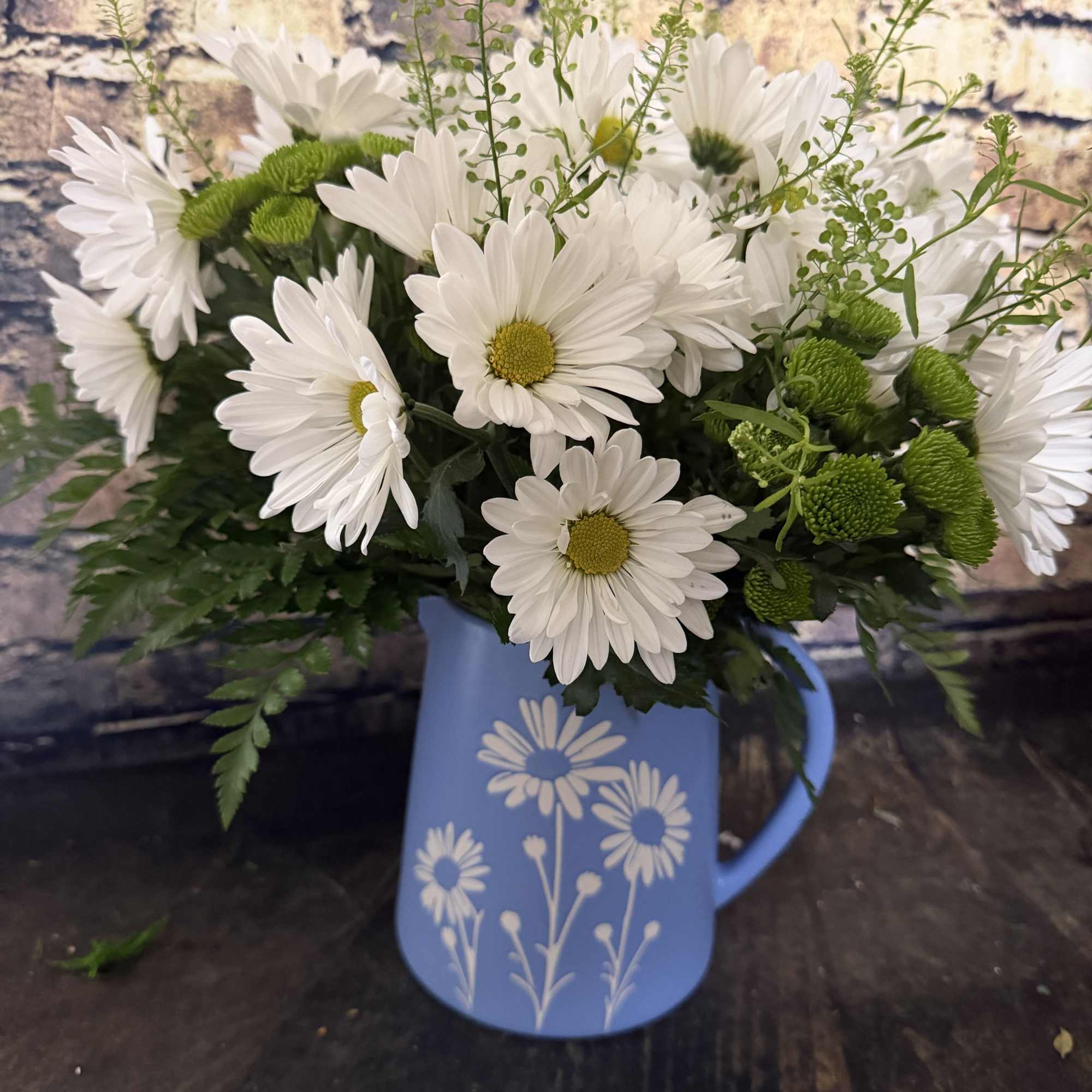 A sparkling glass vase overflowing with sun-kissed daisies is a sure-fire way