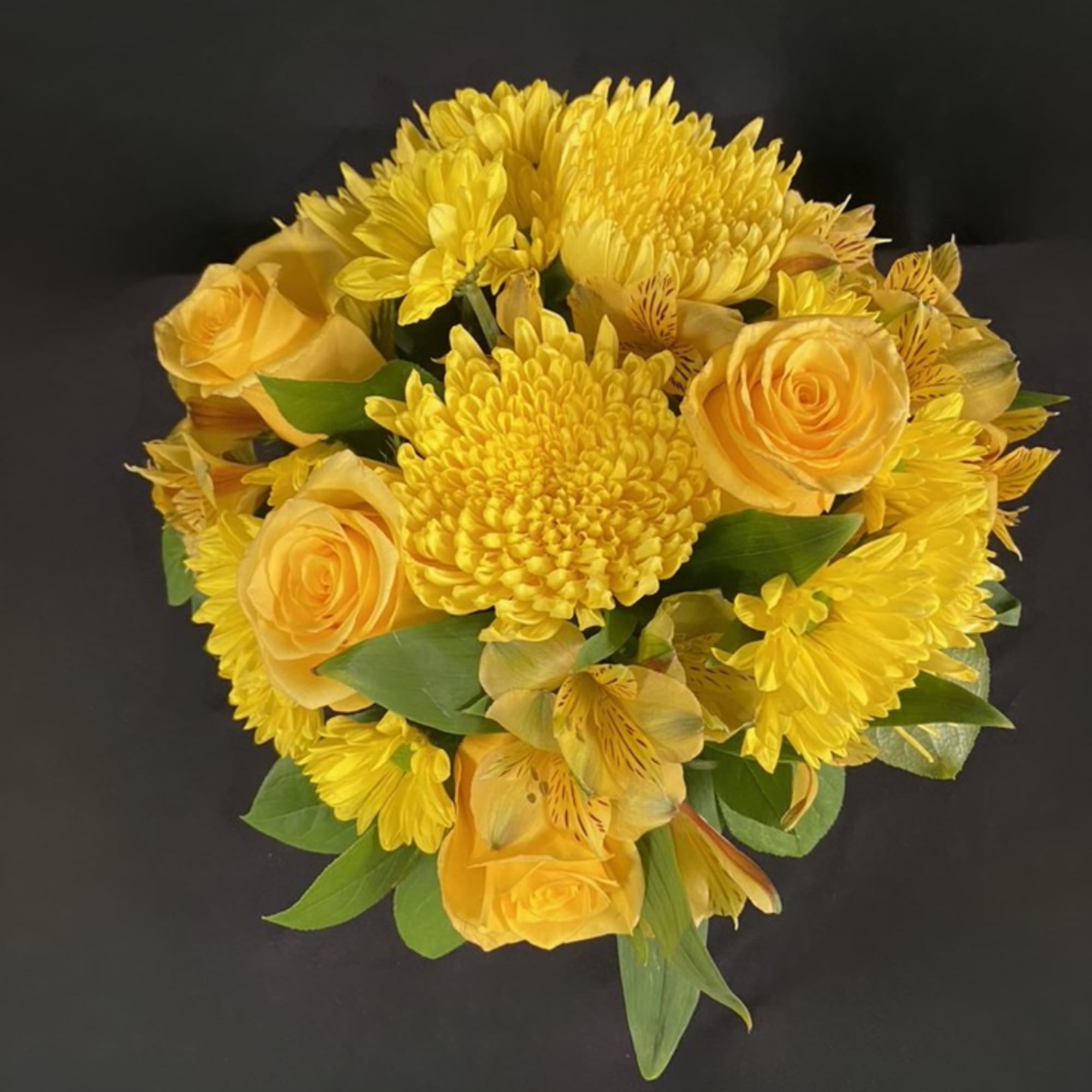 Yellow roses and chrysanthemums arranged in a round bouquet