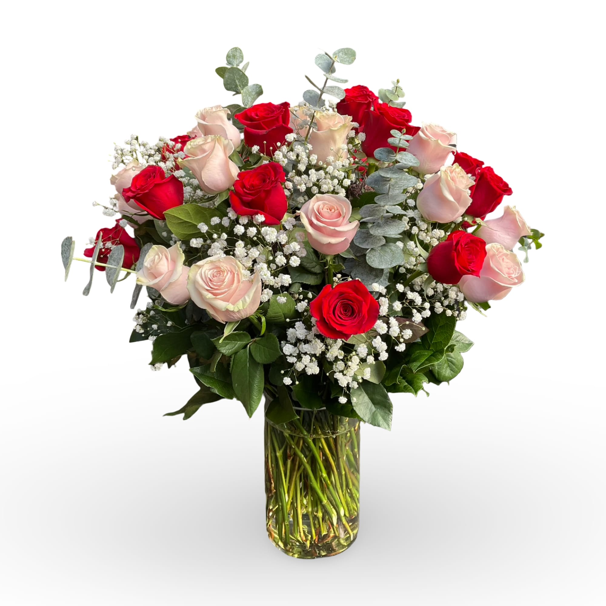Red and blush roses arranged in a clear glass vase