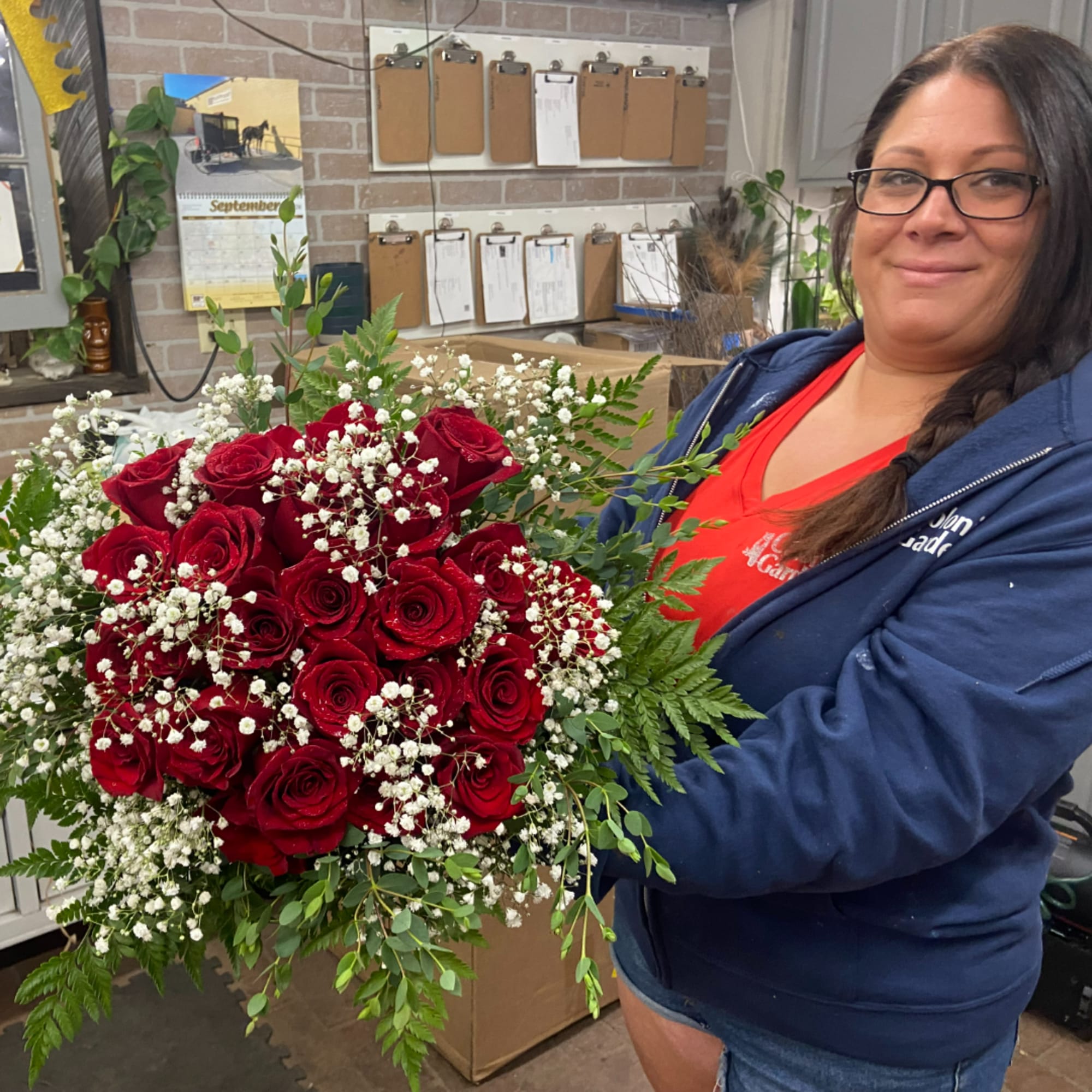 Woman holding a large bouquet of red roses with baby's breath