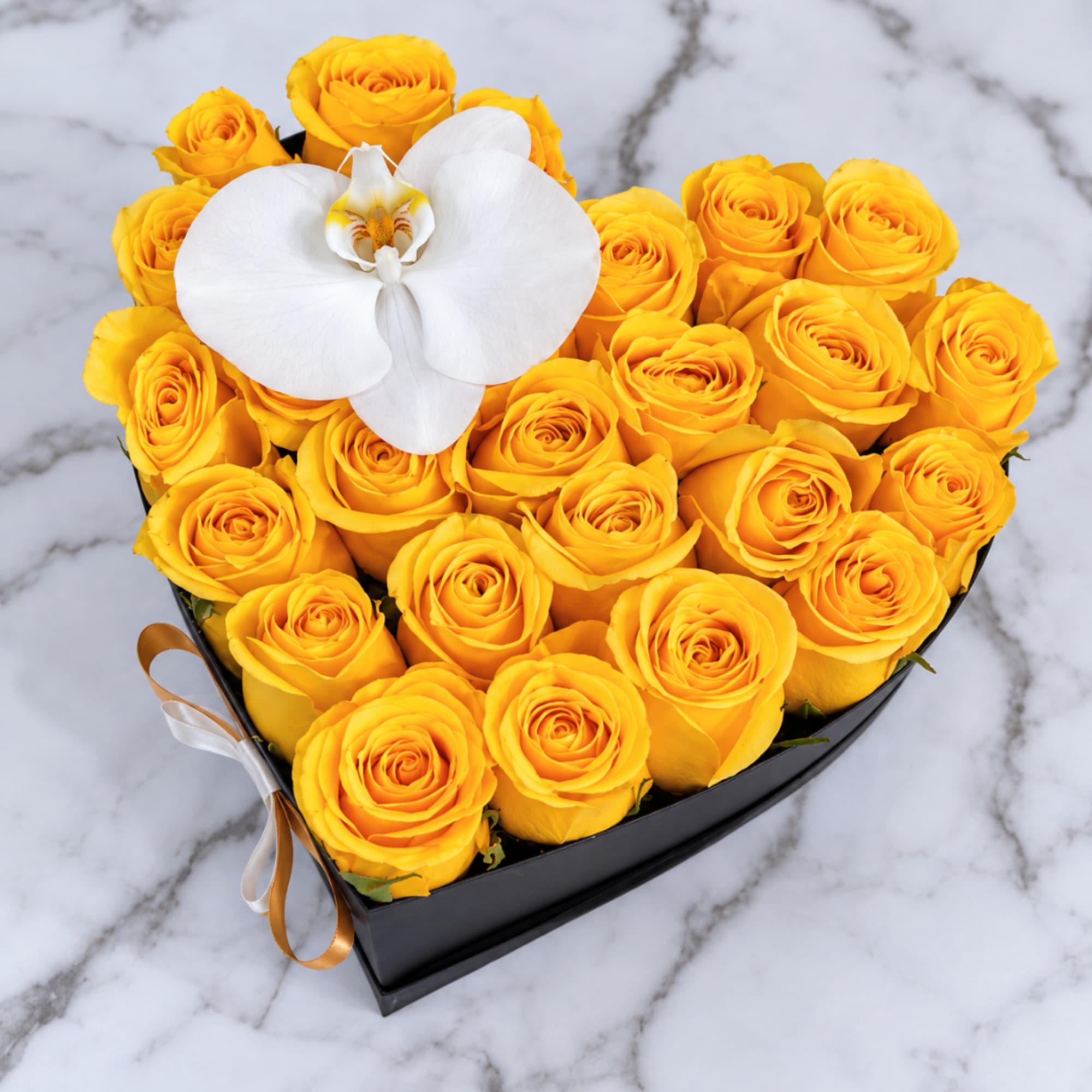 Heart-shaped box of yellow roses with a white orchid on top