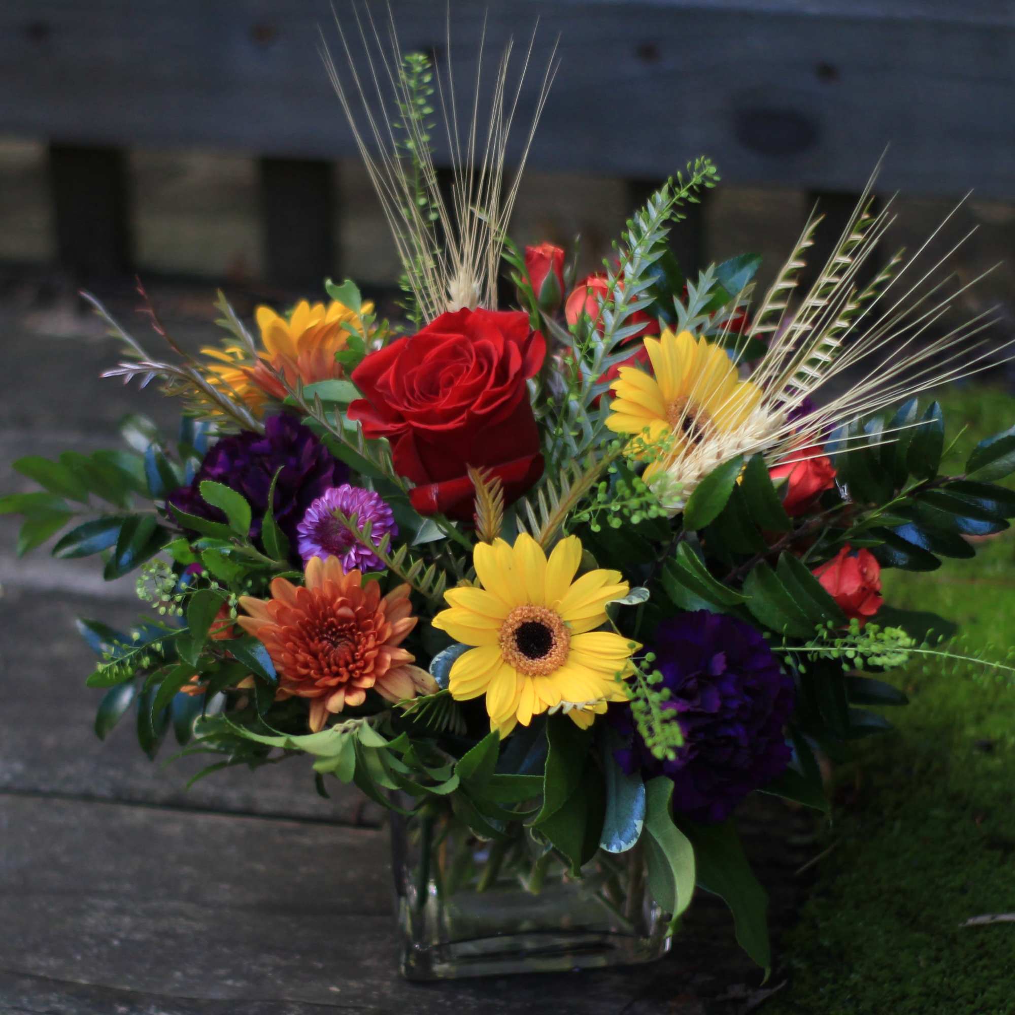 Mixed bouquet with red roses and yellow daisies in a glass vase