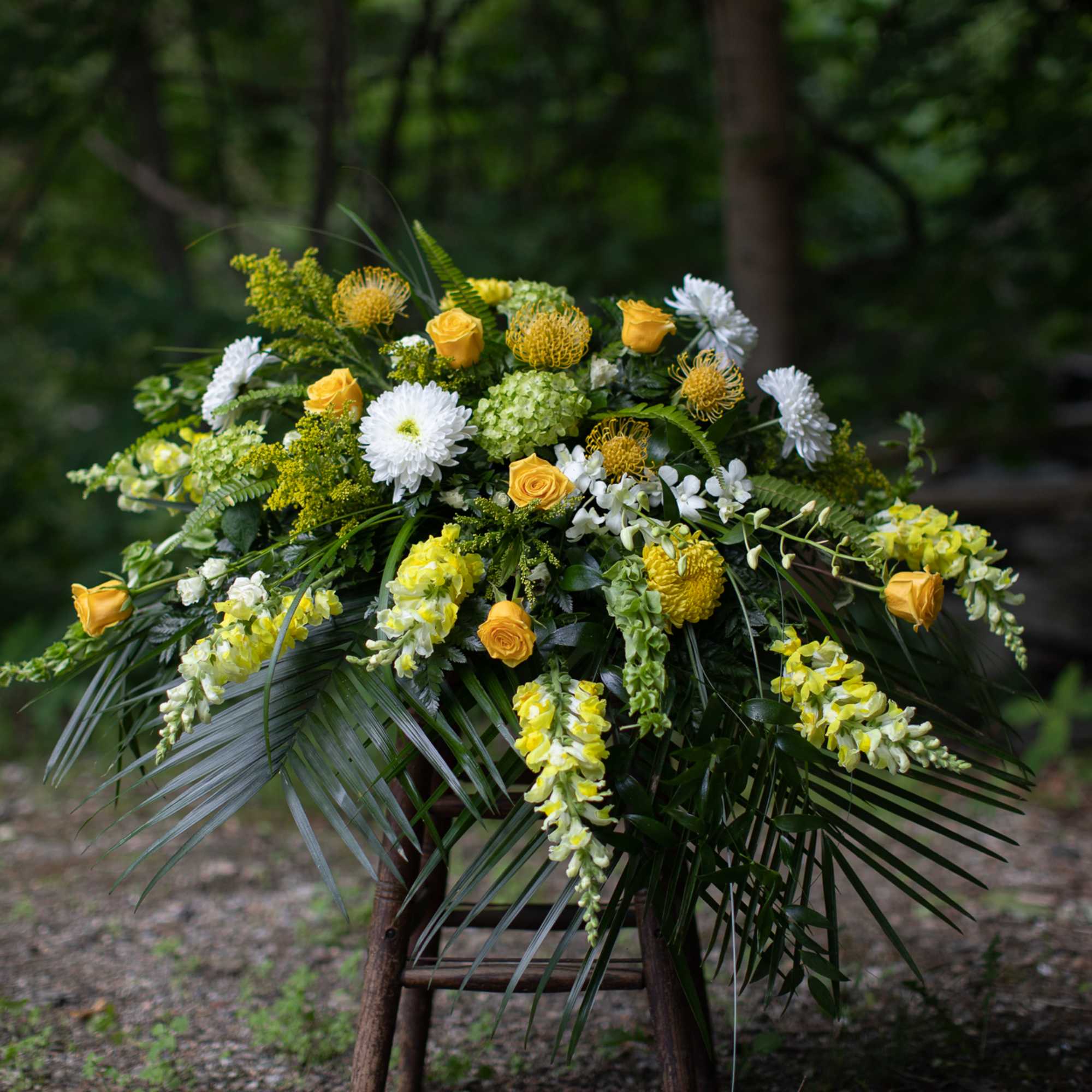 Yellow and white floral arrangement with cascading blooms
