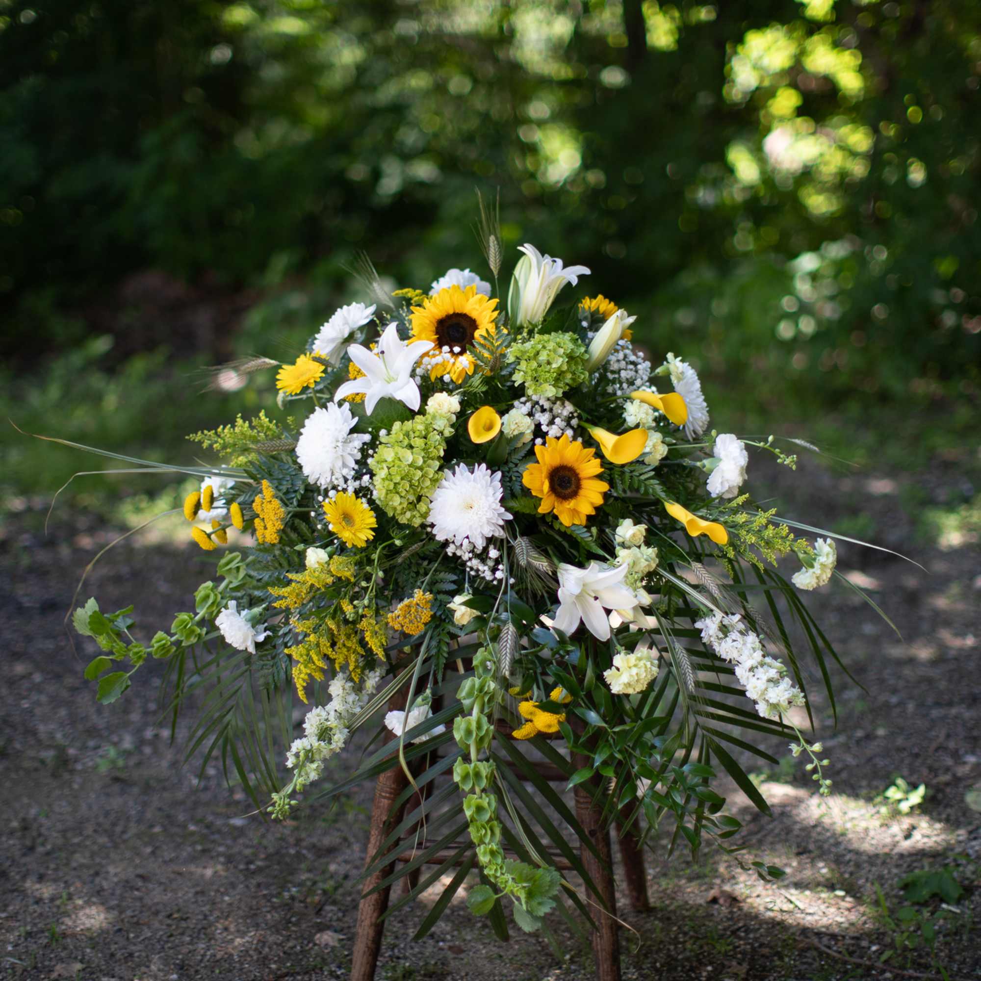 Yellow and white floral spray on a stand outdoors