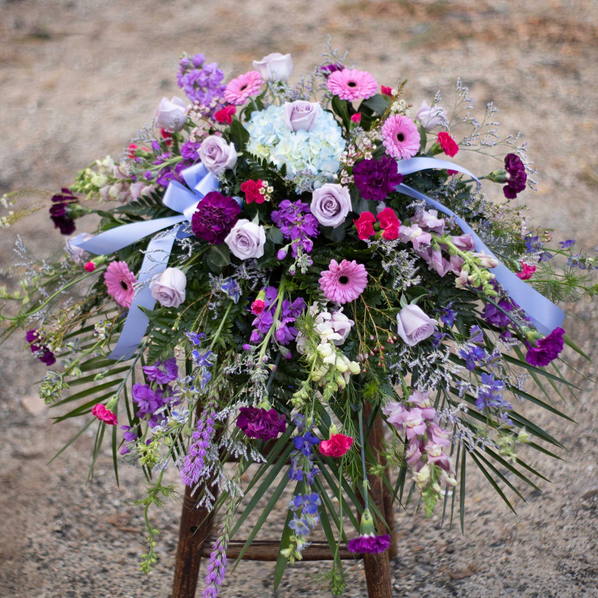 Large mixed floral arrangement with purple, pink, and pale blue blooms