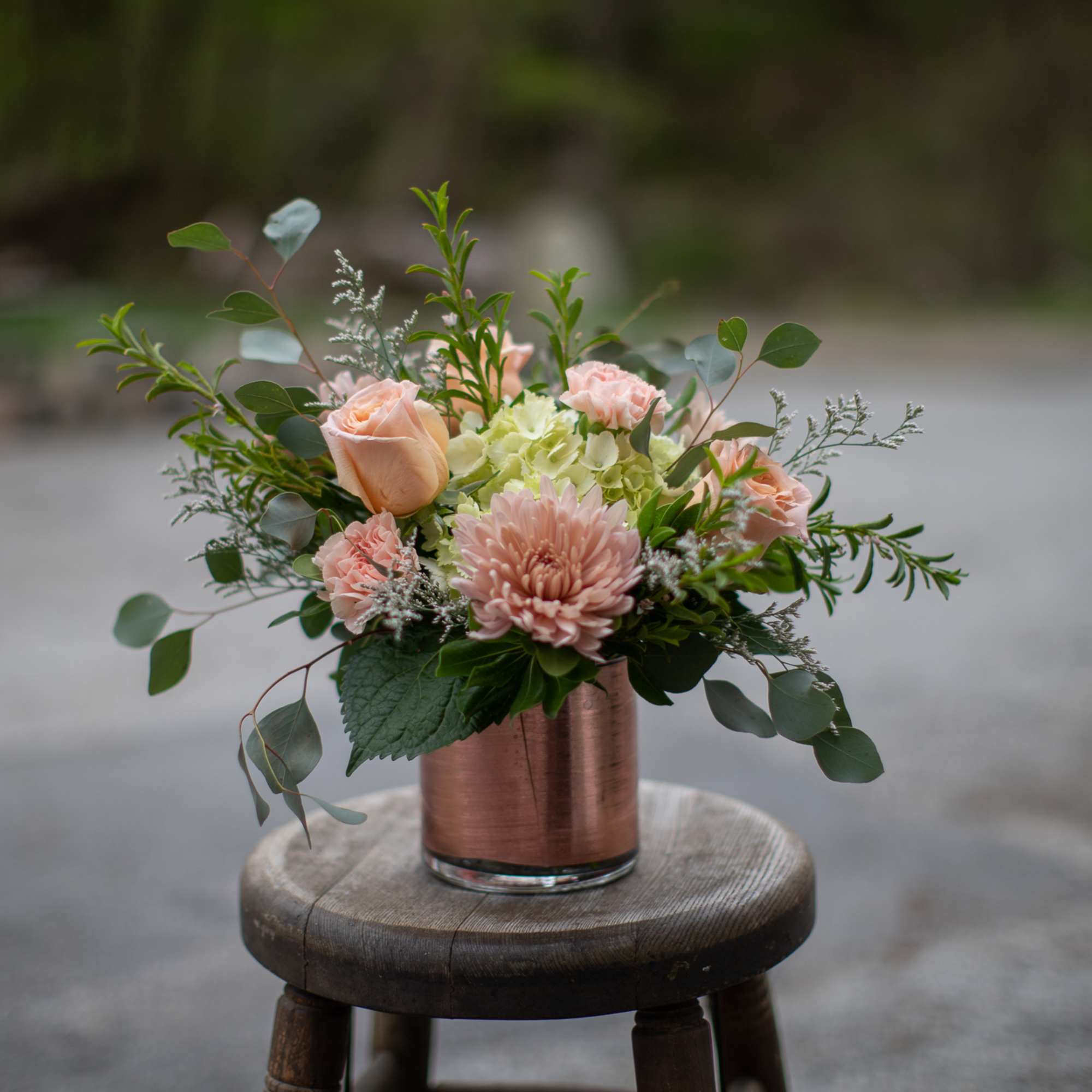 Blush and peach floral arrangement in a copper vase