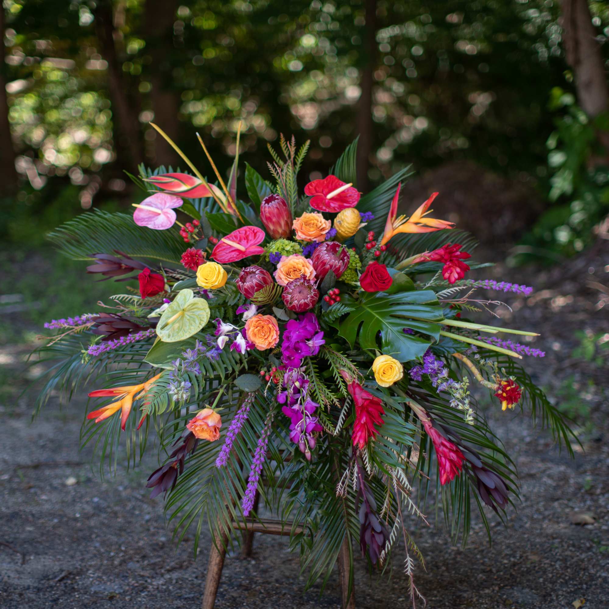 Tropical floral arrangement with bright mixed blooms and palm fronds