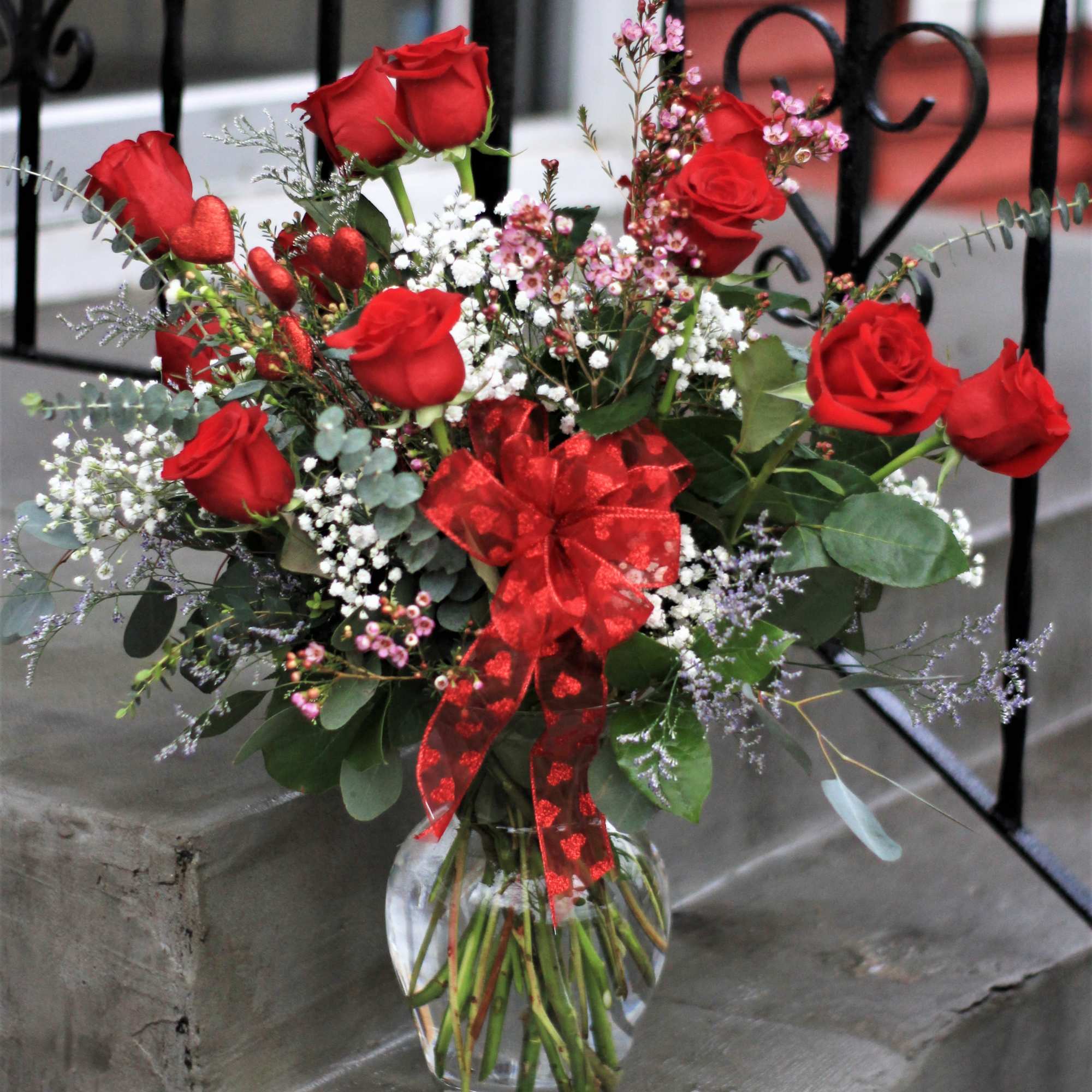 Red roses in a glass vase with a red ribbon bow