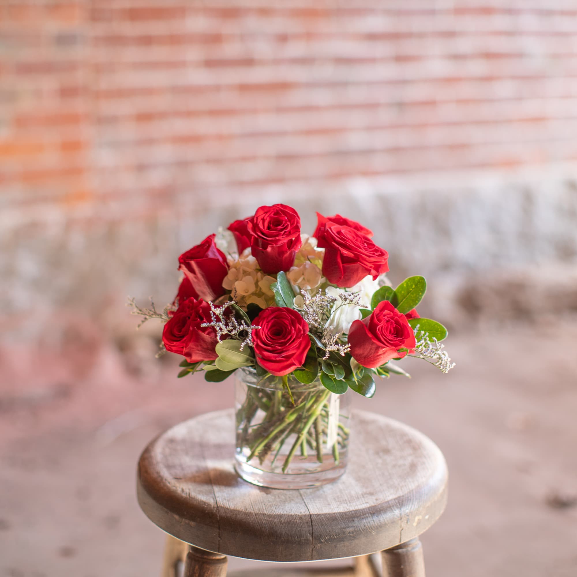 Red roses arranged in a clear glass vase, photo 4 of 5